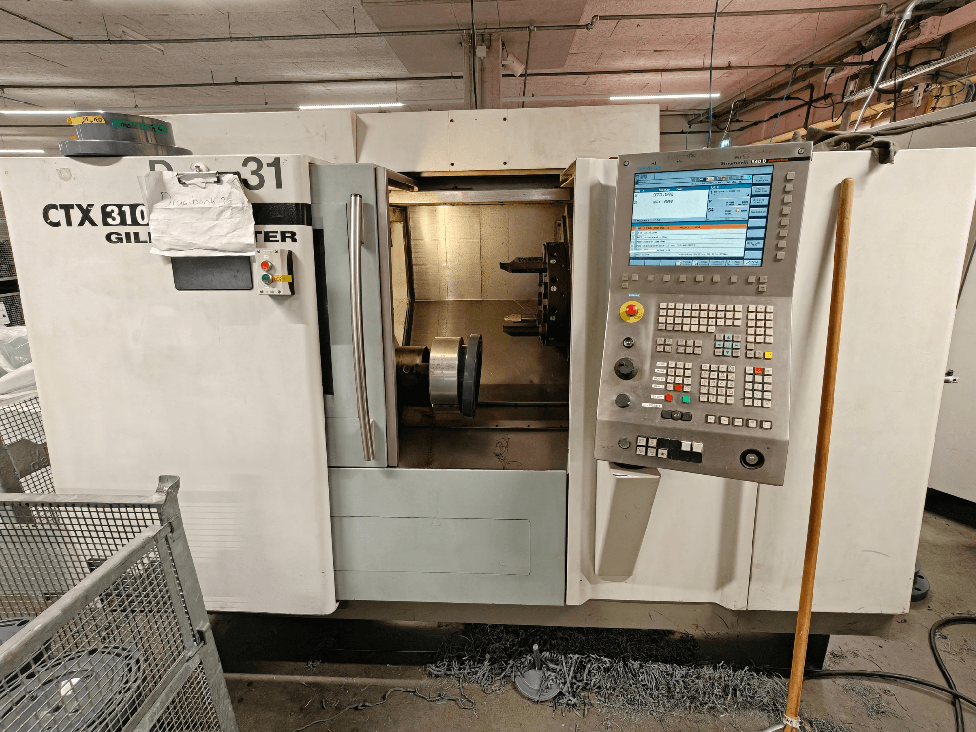 Gildemeister CTX 310 horizontal turning machine, front view with control panel, showing tools and workspace inside.