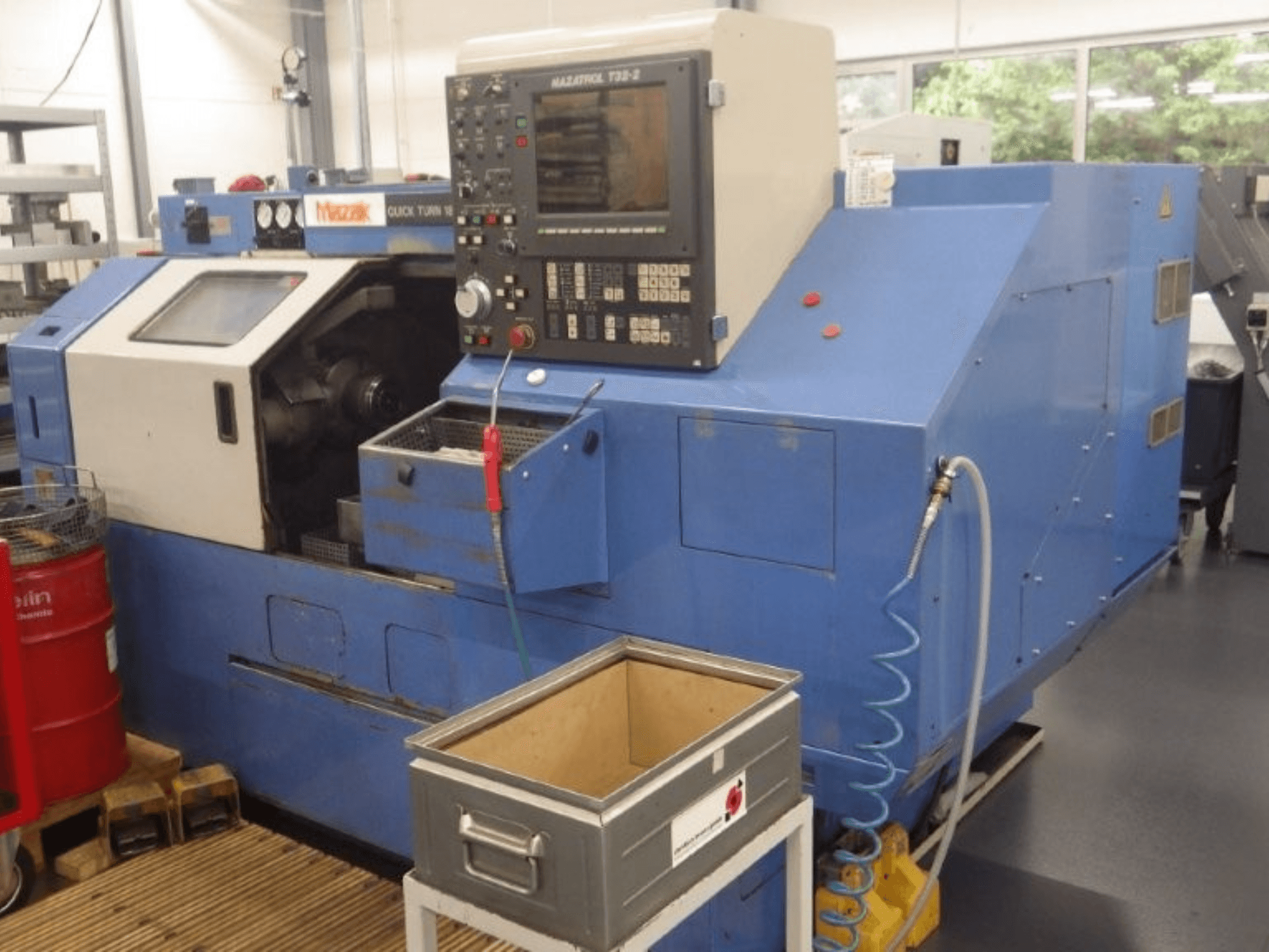 Mazak Quick Turn 18 NSP multi-spindle turning machine, front view, showing control panel, work area, and coolant hose.