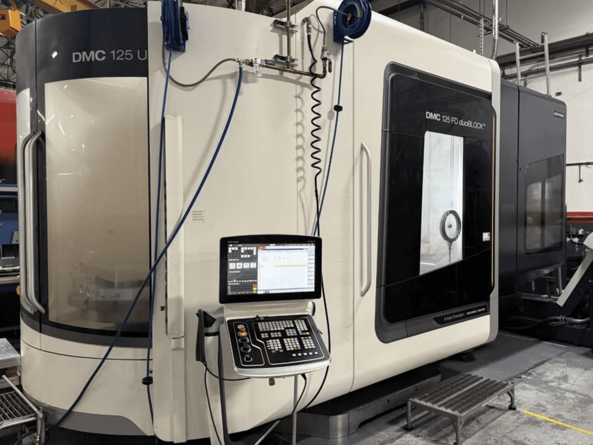 Universal machining center DMG MORI DMC 125 U duoBLOCK, front view with control panel and reflective surfaces.