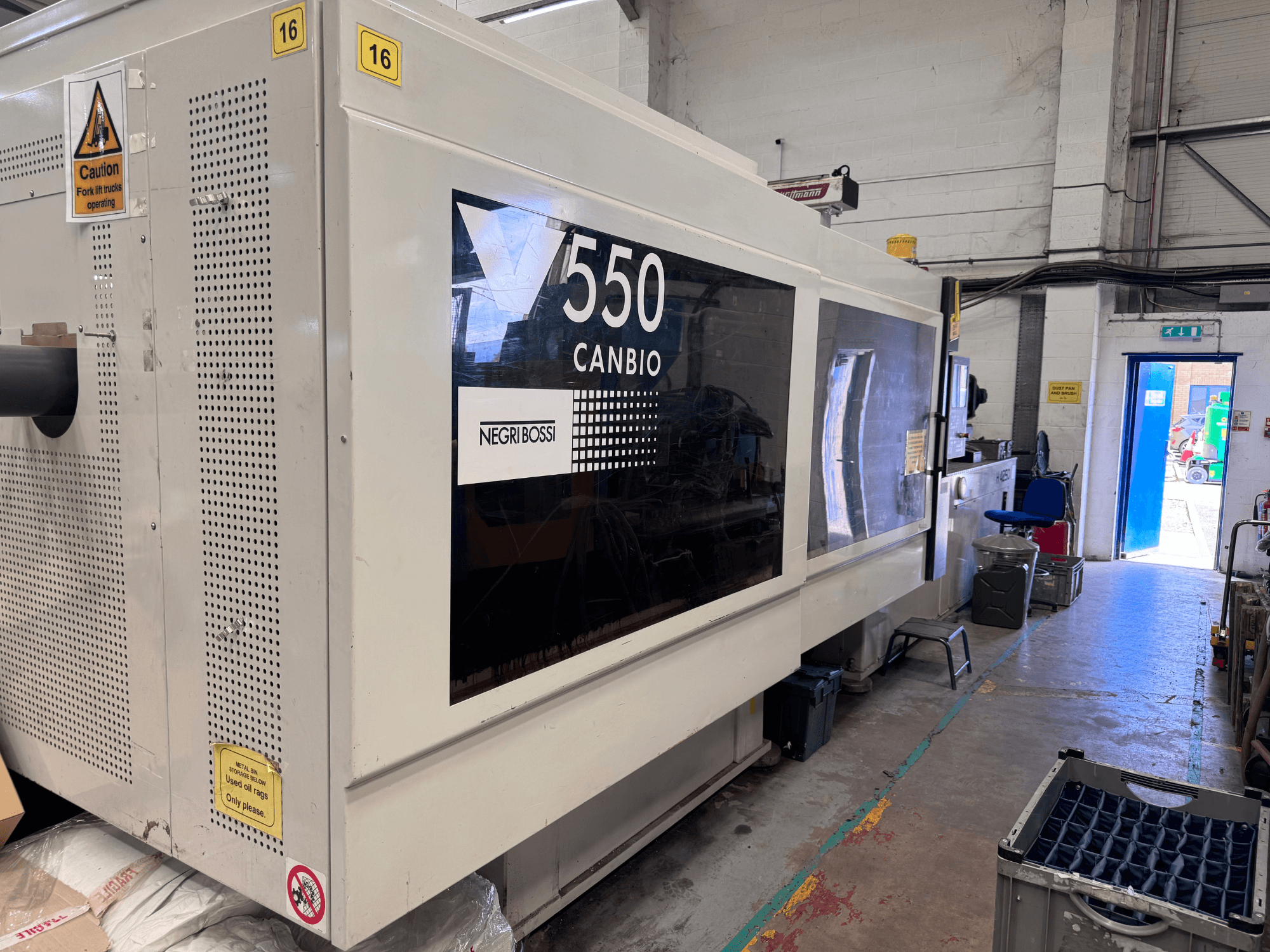 Negri Bossi 5500H-4250 hydraulic injection moulding machine, front view showcasing control panel and warning signs.