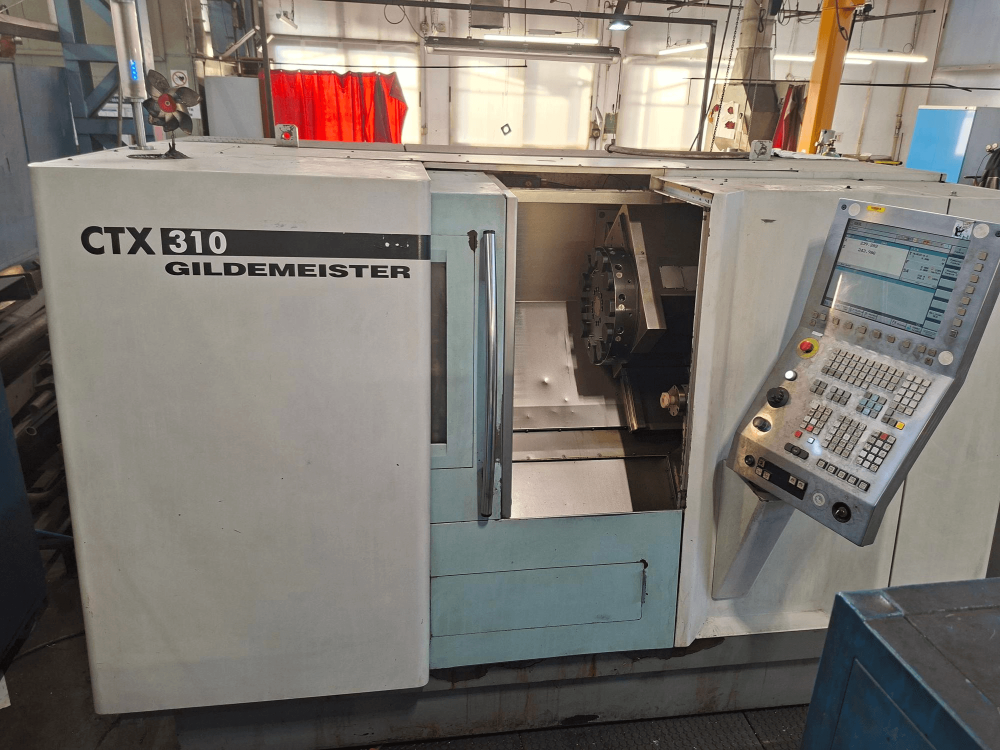 Horizontal turning machine DMG CTX 310, front view, features control panel and open access to the work area.
