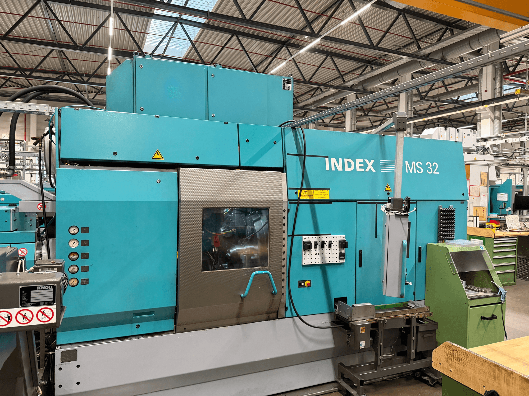 Multi-spindle turning machine Index MS32-P, front view featuring control panel and coolant system. Ideal for precision machining.