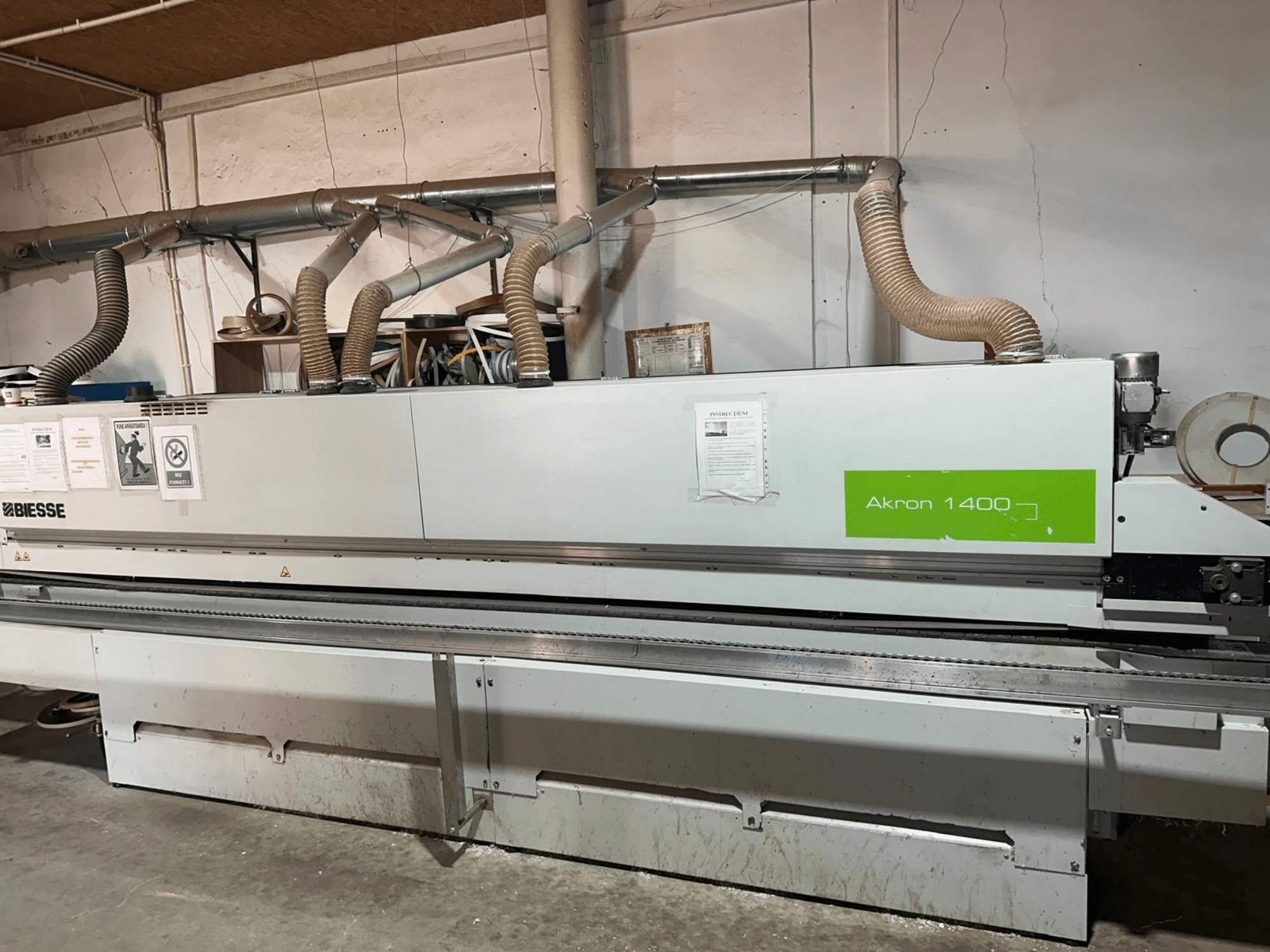 BIESSE Akron 1440 A edgebander in side view, featuring ducting, control panel, and operational stickers.