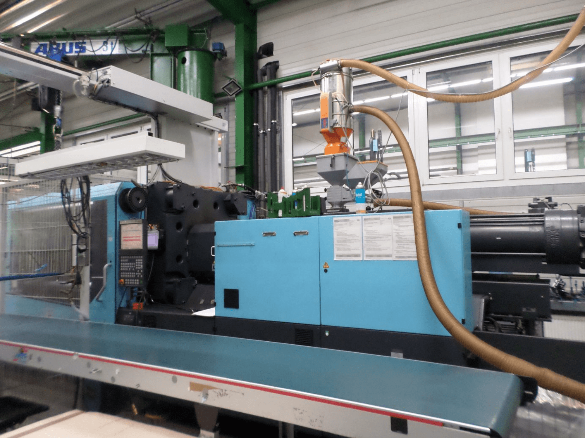 Front view of a DEMAG D 420 hydraulic injection moulding machine, displaying control panel, hopper, and hydraulic components.
