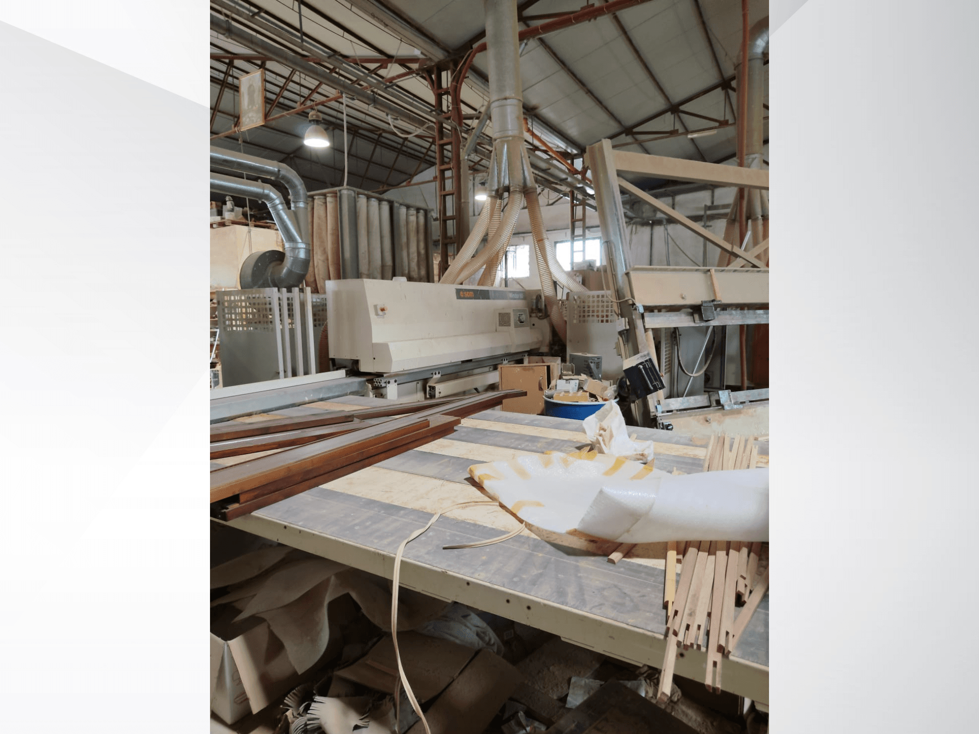 CNC Wood Machining Centre SCM Windor60 in a workshop, viewed from the side with wood panels and dust extraction equipment.