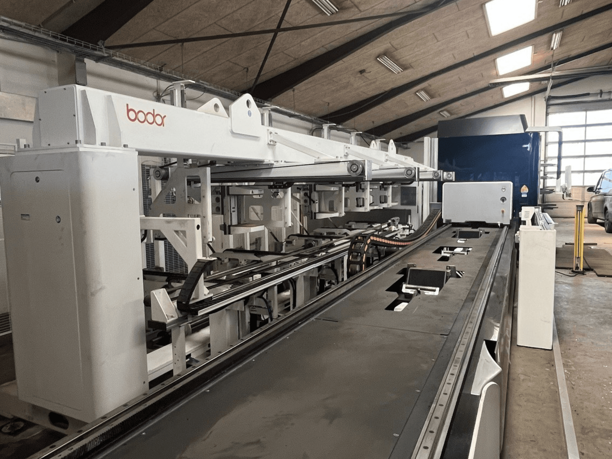 Bodor T2-65-3000W tube cutting machine, viewed from the side, features a sleek design with tracks for precise cutting alignment.
