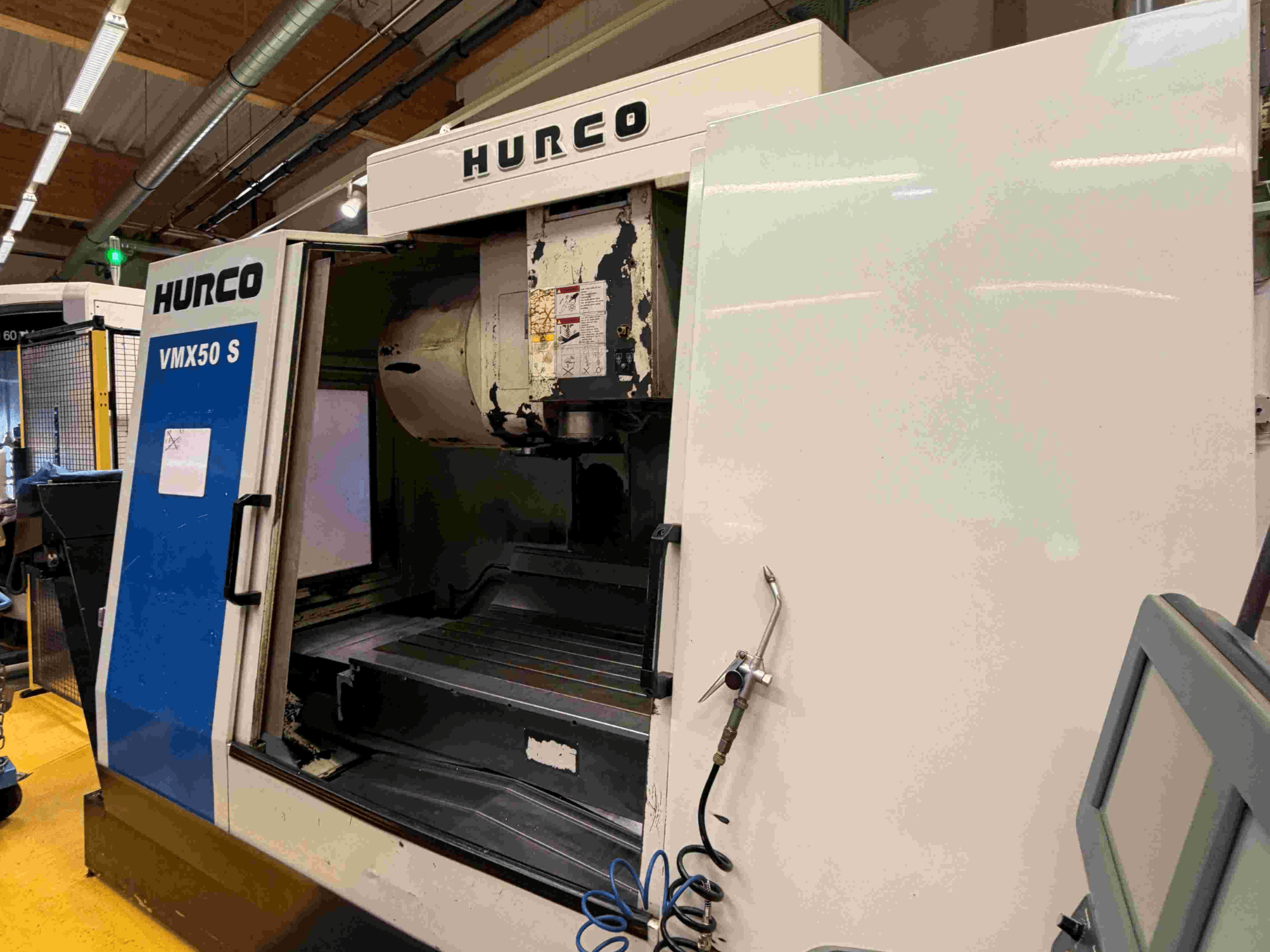 Hurco VMX50 S vertical machining center, side view, showcasing the open door and control panel.