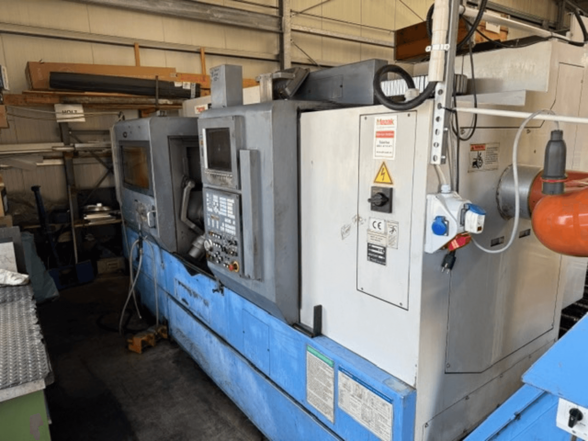 Mazak SQT-30M * 1000 Turn-Mill Centre, side view showing control panel, blue base, and surrounding equipment in workshop.