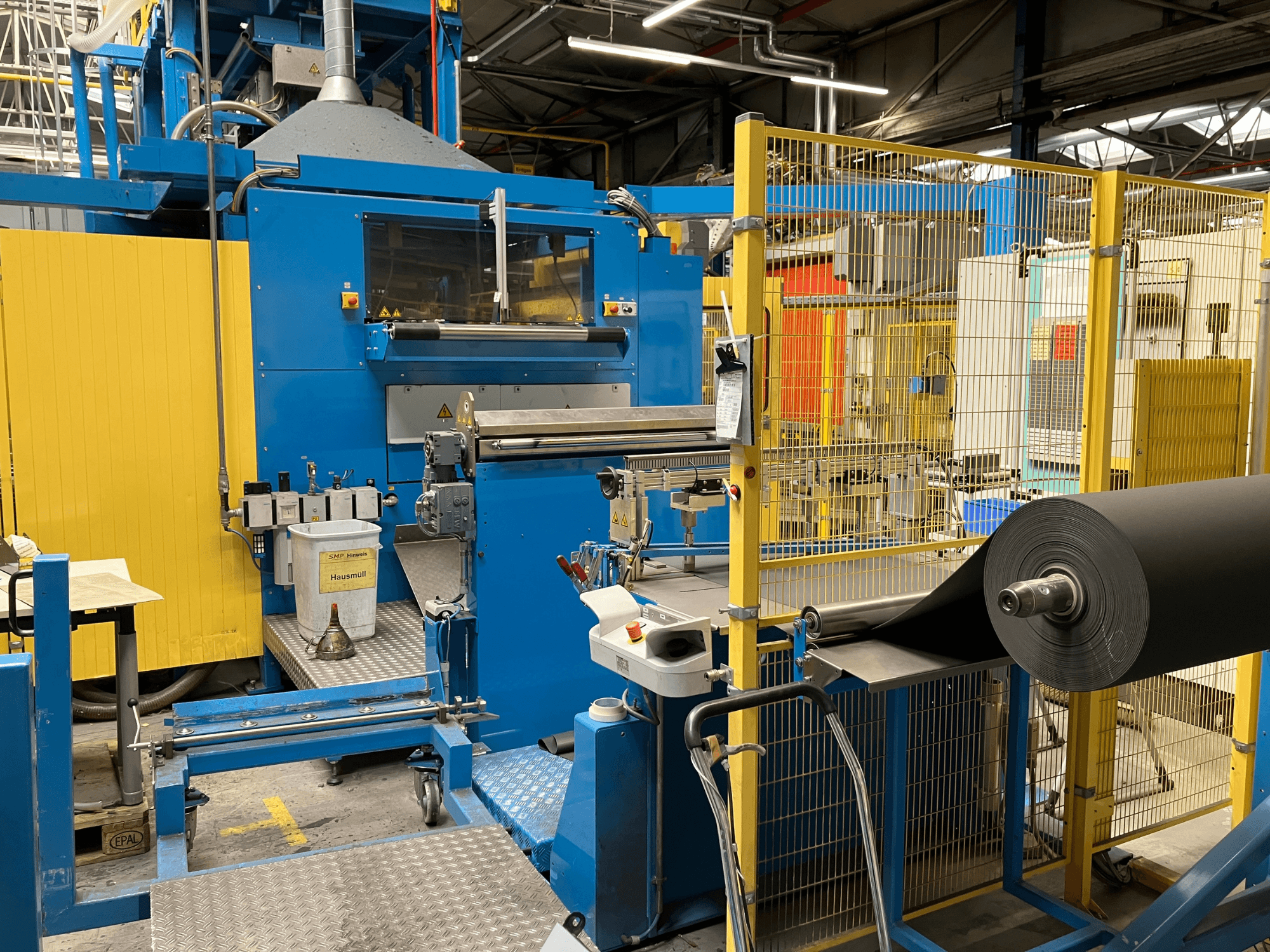 KIEFEL KLS 86/235 plastic processing machine viewed from the front, featuring a roll of black material and control panel.