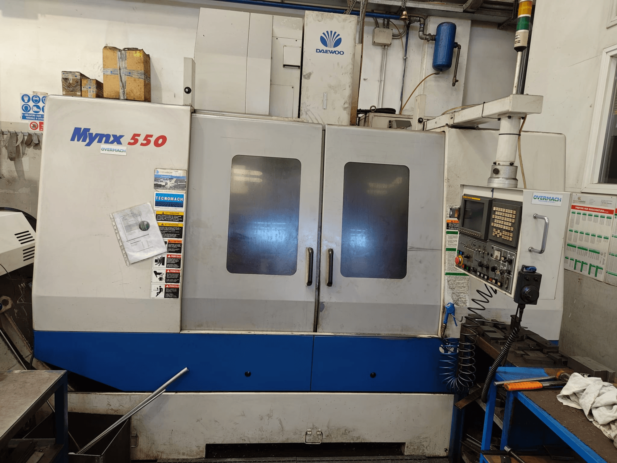 Vertical machining centre DAEWOO MYNX 550, front view, featuring control panel, two large doors, and safety labels.