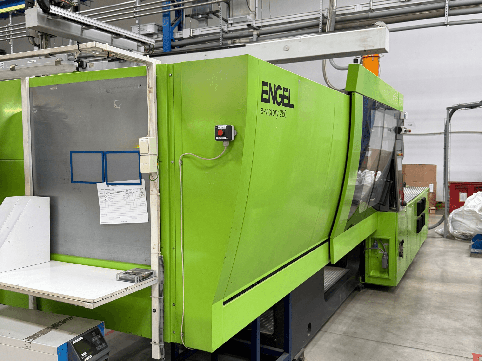 Green Engel e-victory 260 electrical injection moulding machine from a side view, featuring a control panel and work surface.