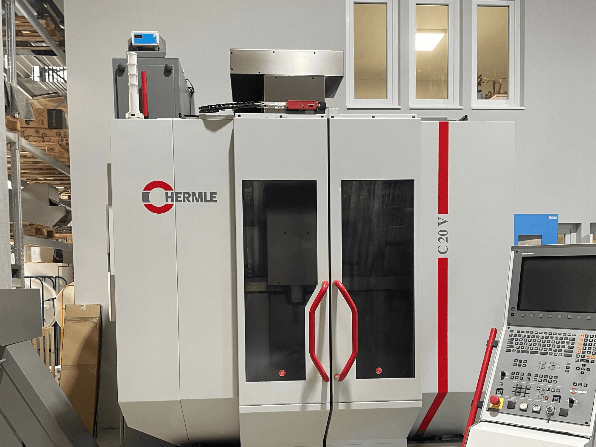 Chermle C20 V CNC machine, front view, featuring a control panel and red handles; industrial design with large glass doors.