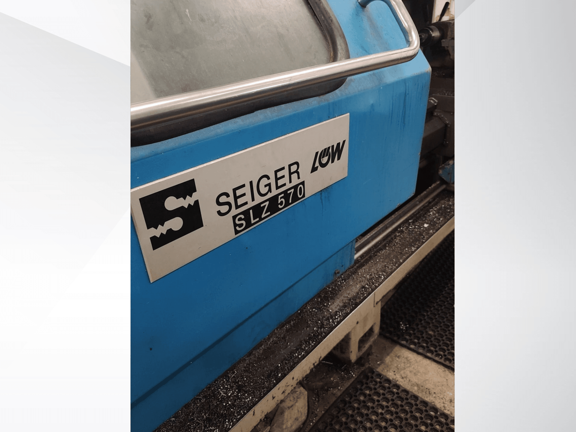Close-up side view of SEIGER SLZ570 turning machine with blue exterior and logo, showcasing operational control features.