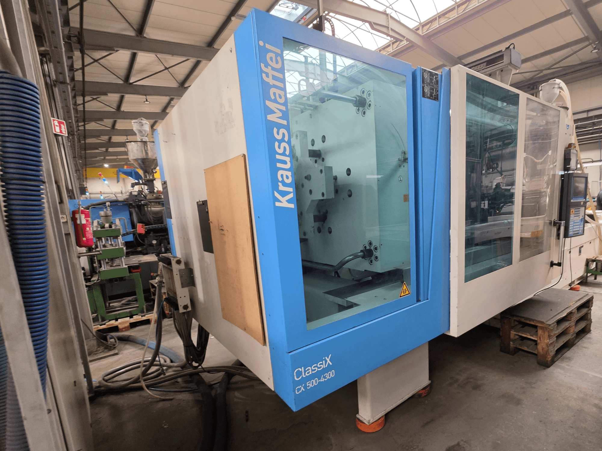 Krauss Maffei 500-4300 CX hydraulic injection moulding machine, side view, showcasing control panel and operational components.