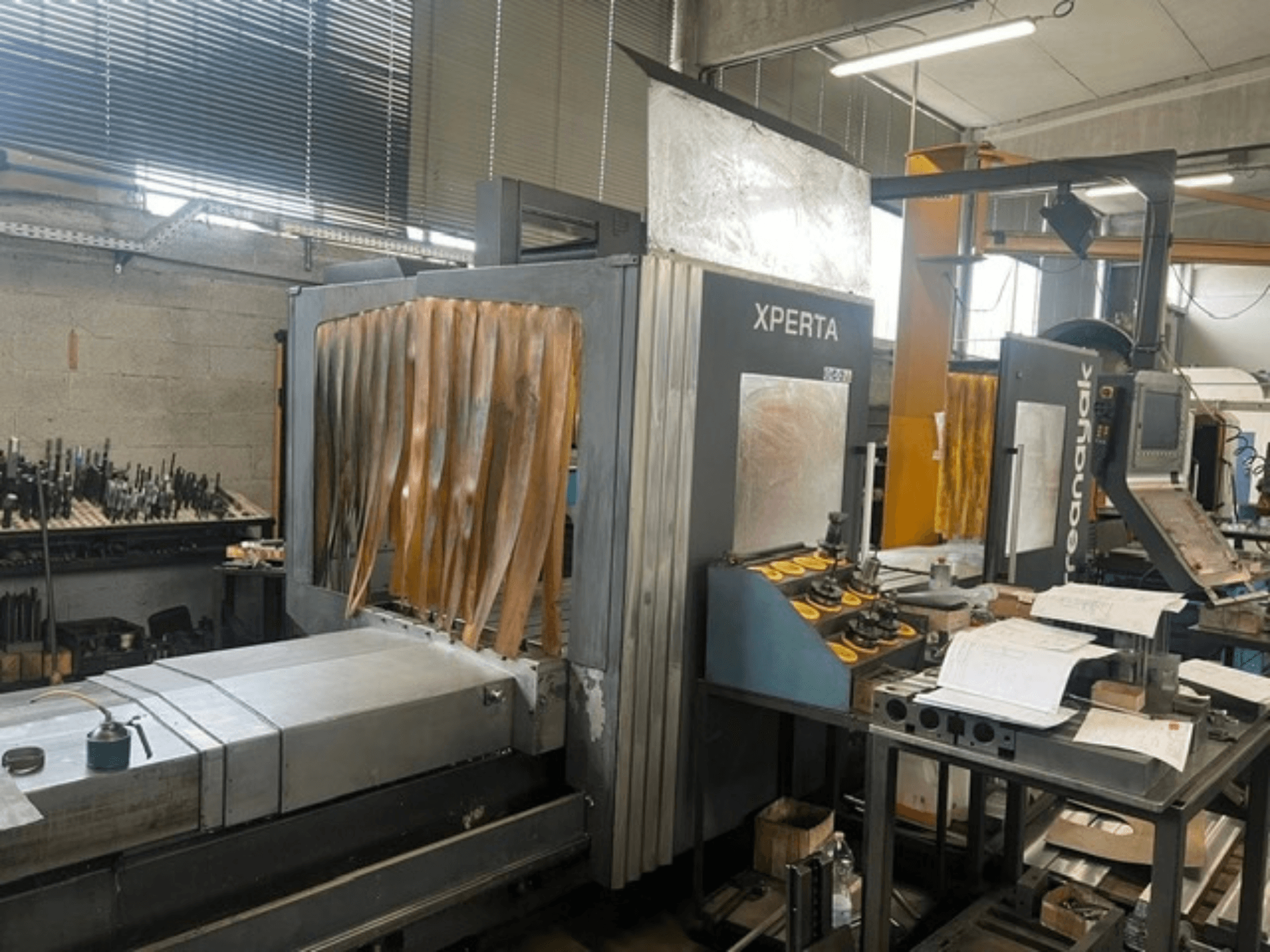 Front view of the ANAYAK CORREA XPERTA 25 vertical machining center, featuring control panel and machining bed in a workshop setting.