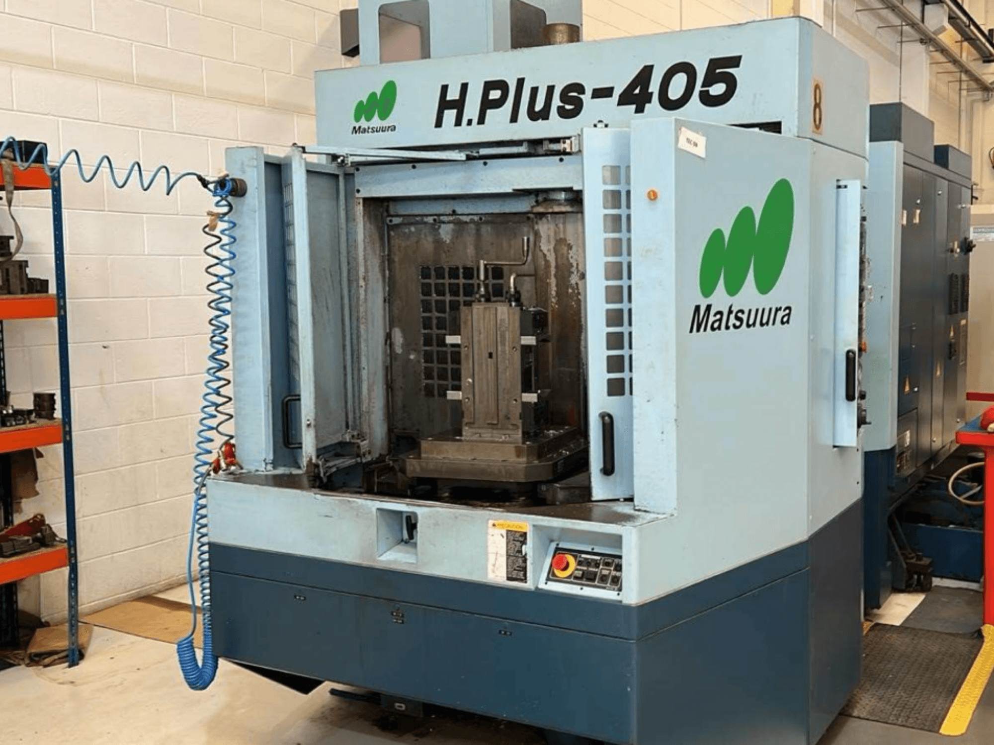 Front view of a Matsuura H.Plus 405 horizontal machining center with an open door, showcasing the workspace and control panel.