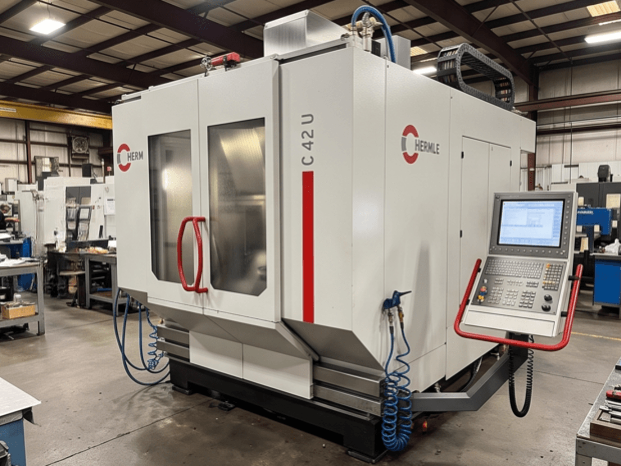 HERMLE C42 Universal Machining Centre in a workshop, front view showcasing control panel and machine details.