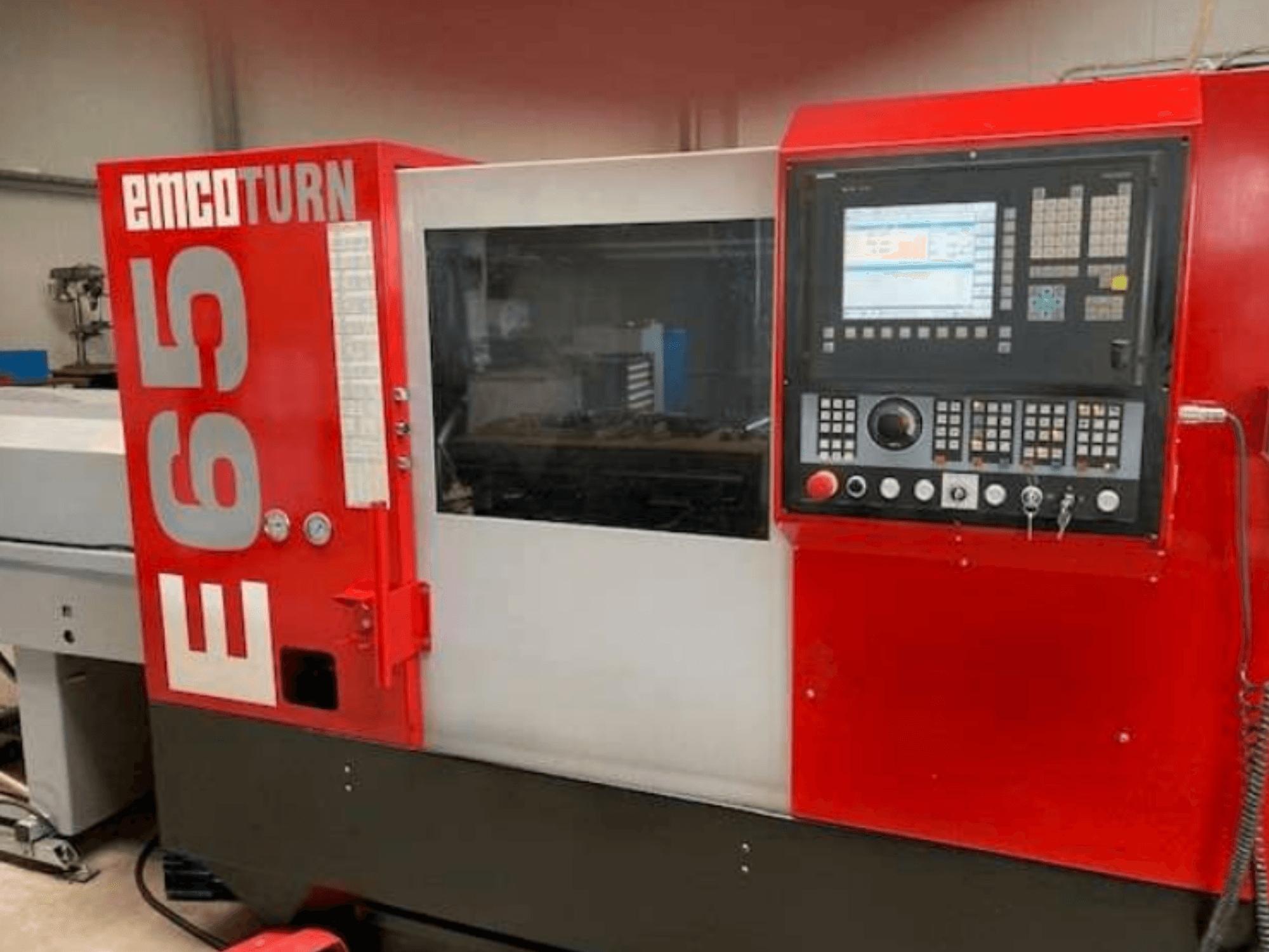 EMCO Turn E65 CNC lathe, front view showing control panel, large display, and work area behind glass.
