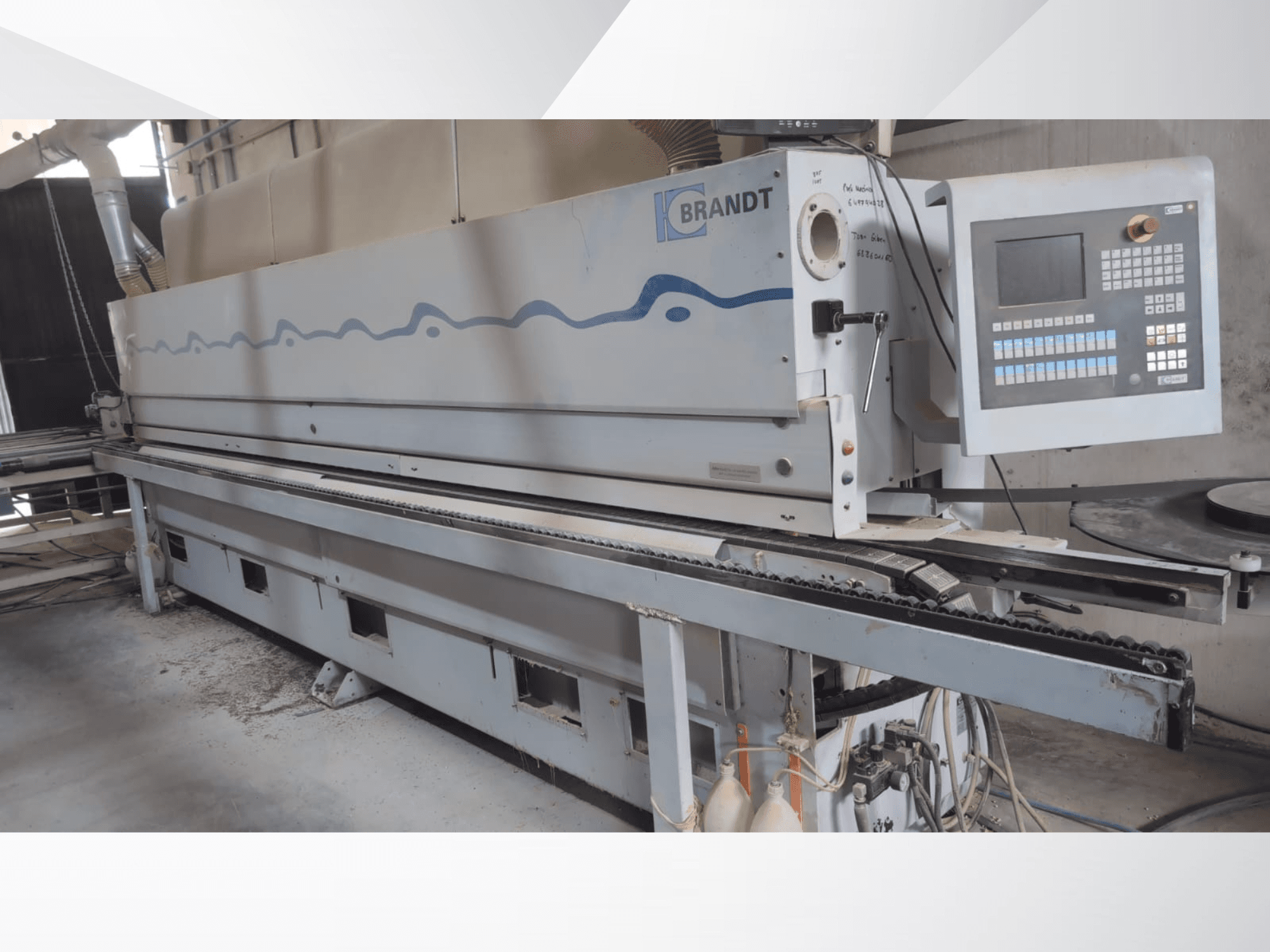 Edgebander BRANDT KDF 560 in front view, featuring control panel and feeding conveyor, with visible dust residue on the floor.