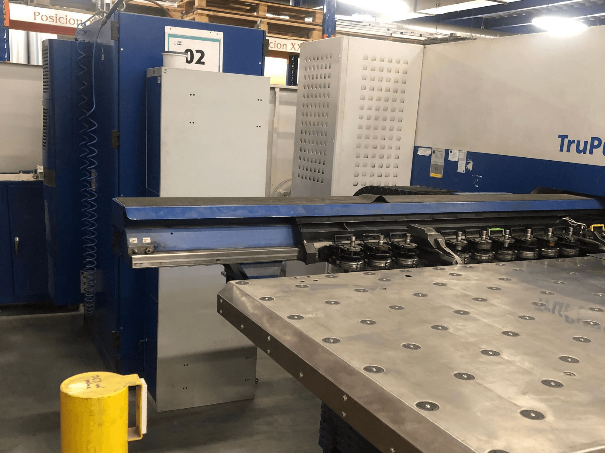 TRUMPF TruPunch 5000 CNC punching machine, front view showing the tool turret and control panel, with a metal worktable nearby.