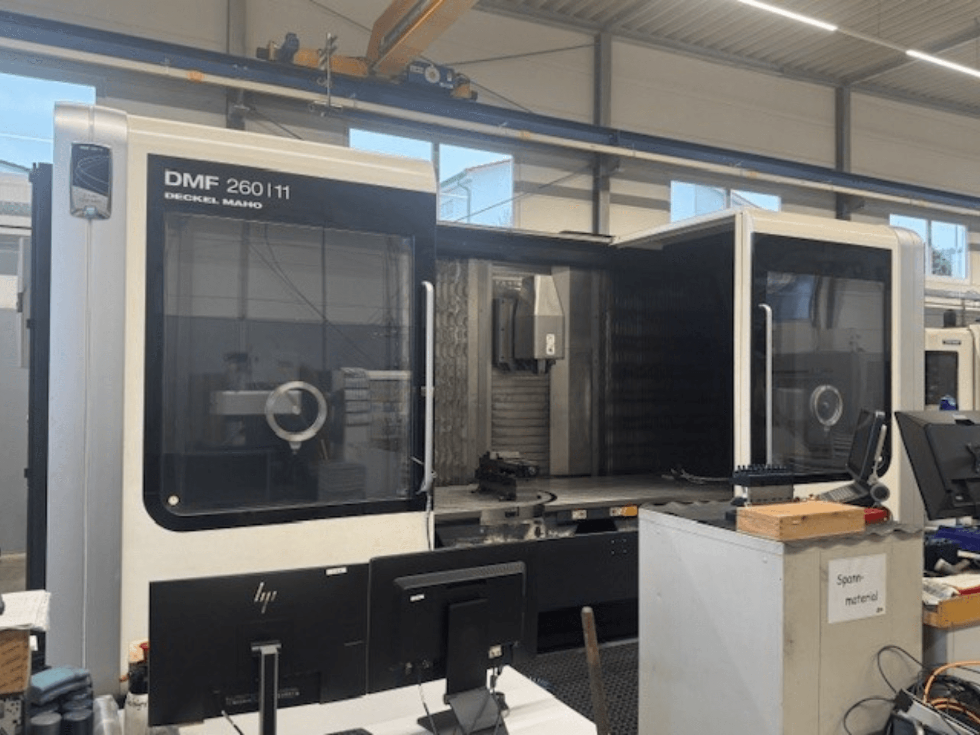 Universal machining center DECKEL MAHO DMF 260/11 in front view, showcasing a spacious operating area and control screens.