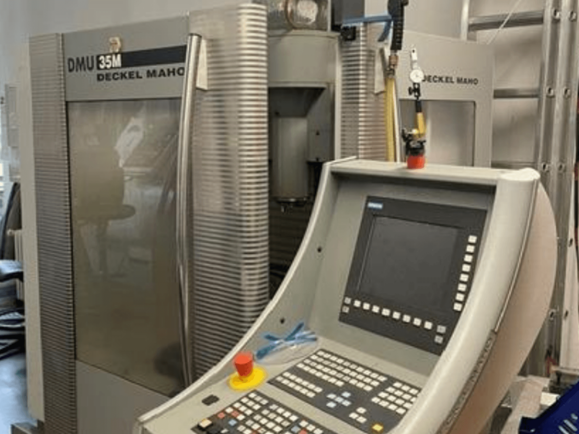 Front view of DECKEL MAHO DMU 35M universal machining centre showing control panel and machine details.