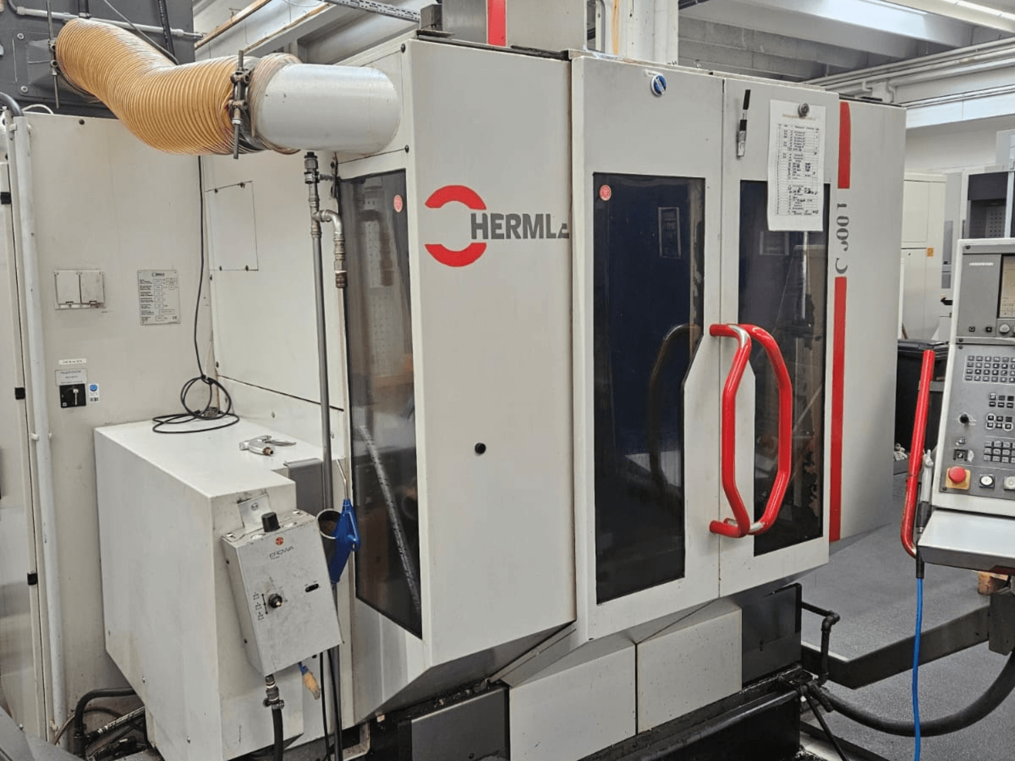 Front view of HERMLE C 600 U universal machining center, showing control panel and red handles on doors.