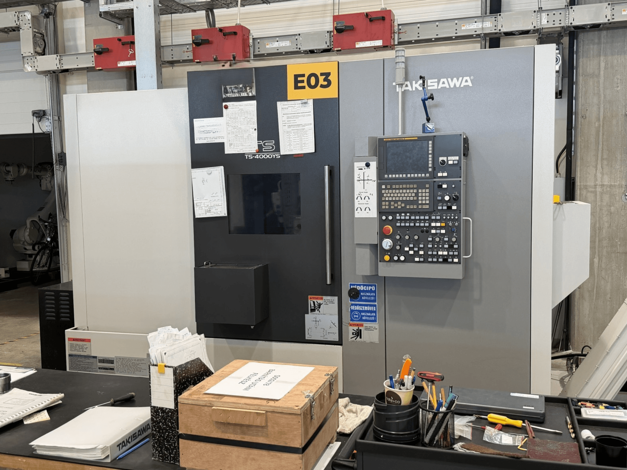 Turn-mill centre Takisawa TS-4000YS viewed from the front, showcasing control panel and documents on the side.