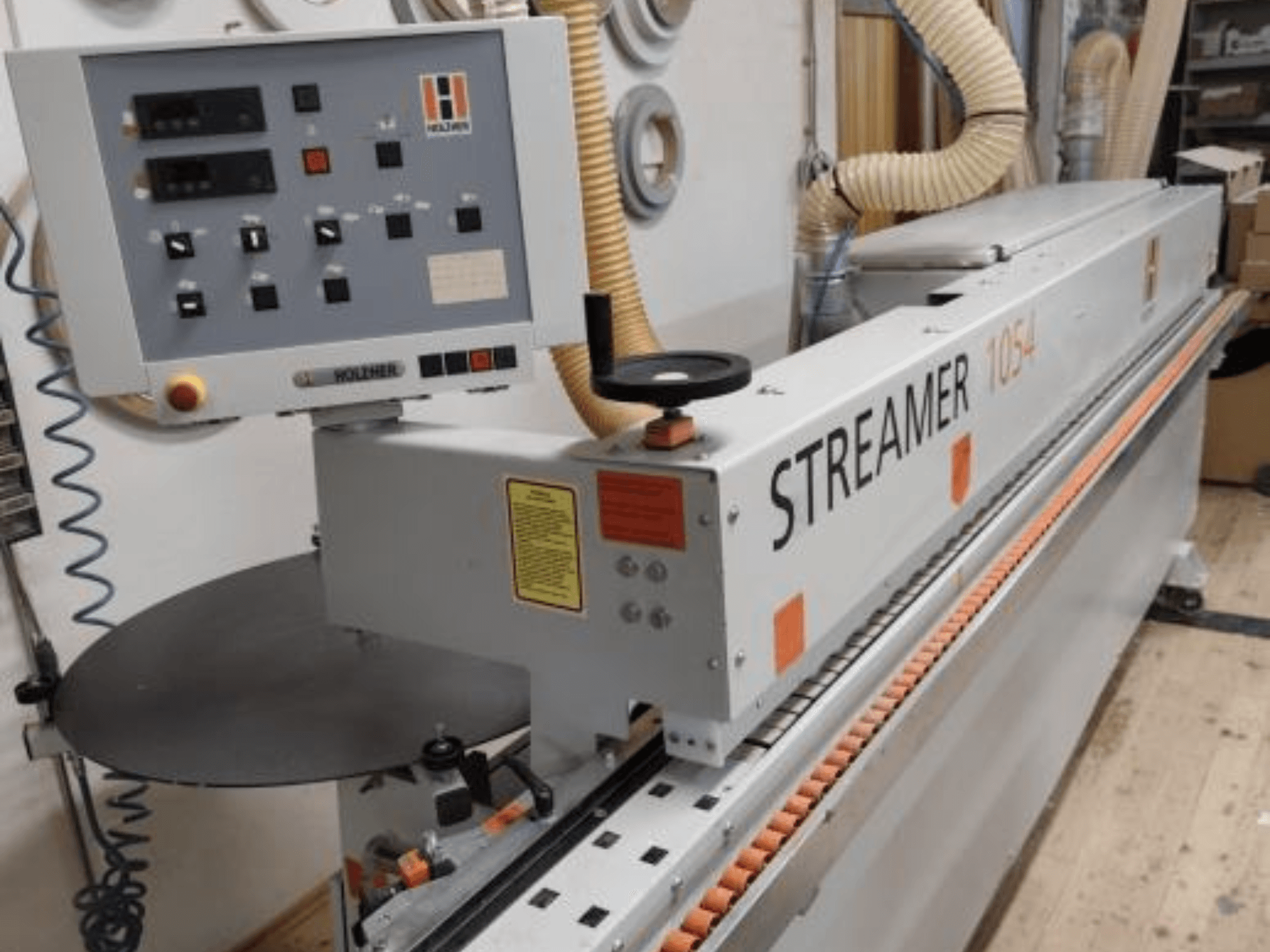 HOLZHER Streamer 1054 edgebander, side view showcasing control panel and feed system on a workshop background.