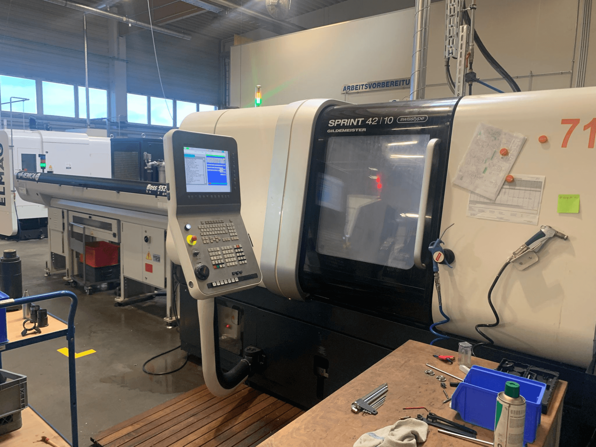 DMG MORI Sprint 42/10 linear Swiss Type Turning Machine, front view, featuring a control panel and workspace clutter.
