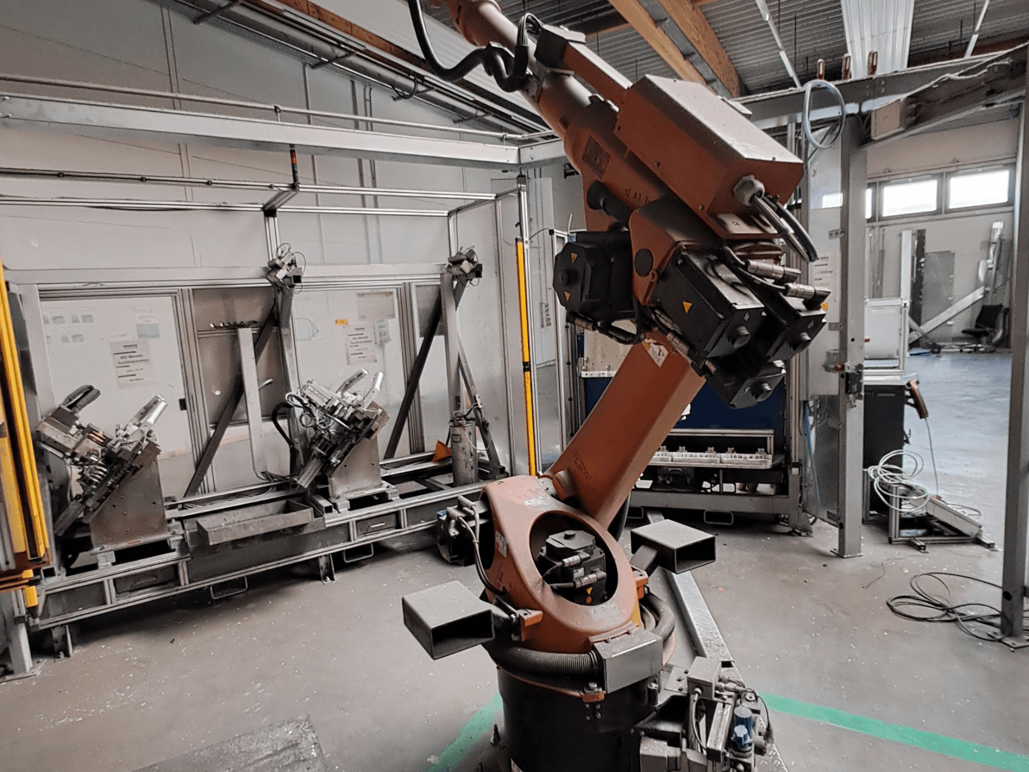 KUKA KR 30L16-2 robot arm in a industrial setting, side view, showcasing the arm's joints and gripping tools.