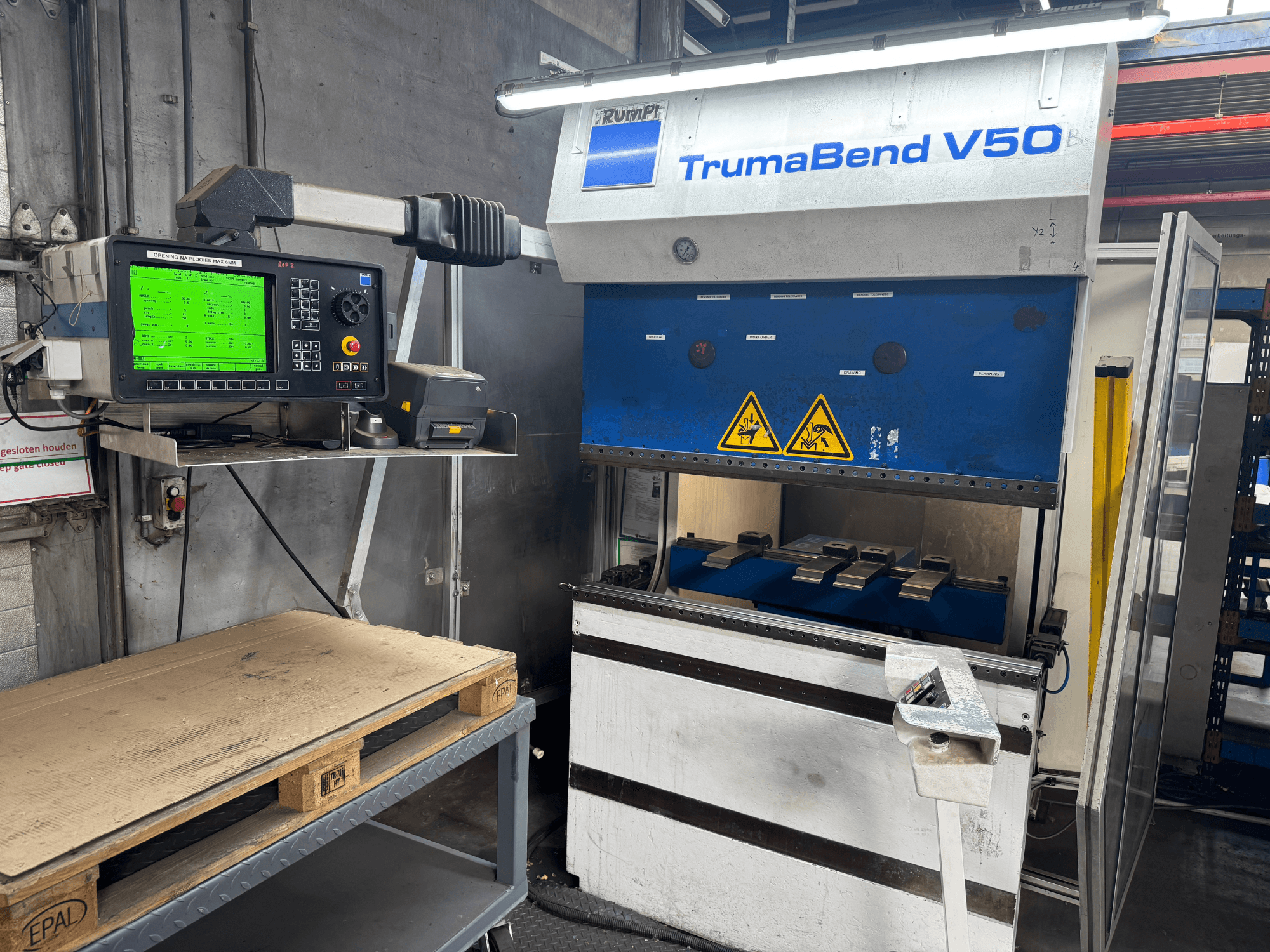 TRUMPF TrumaBend V50 press brake, front view, with control panel displaying settings and safety warning signs.