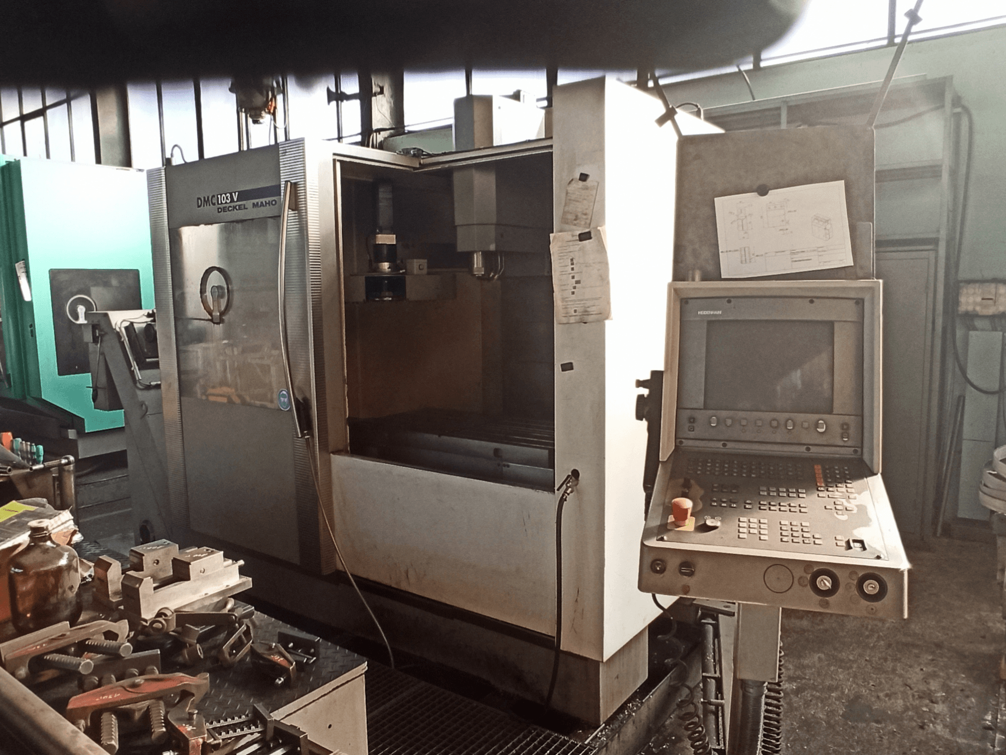 DECKEL MAHO DMC 103 V vertical machining center in a workshop, front view showing control panel and cutting area.