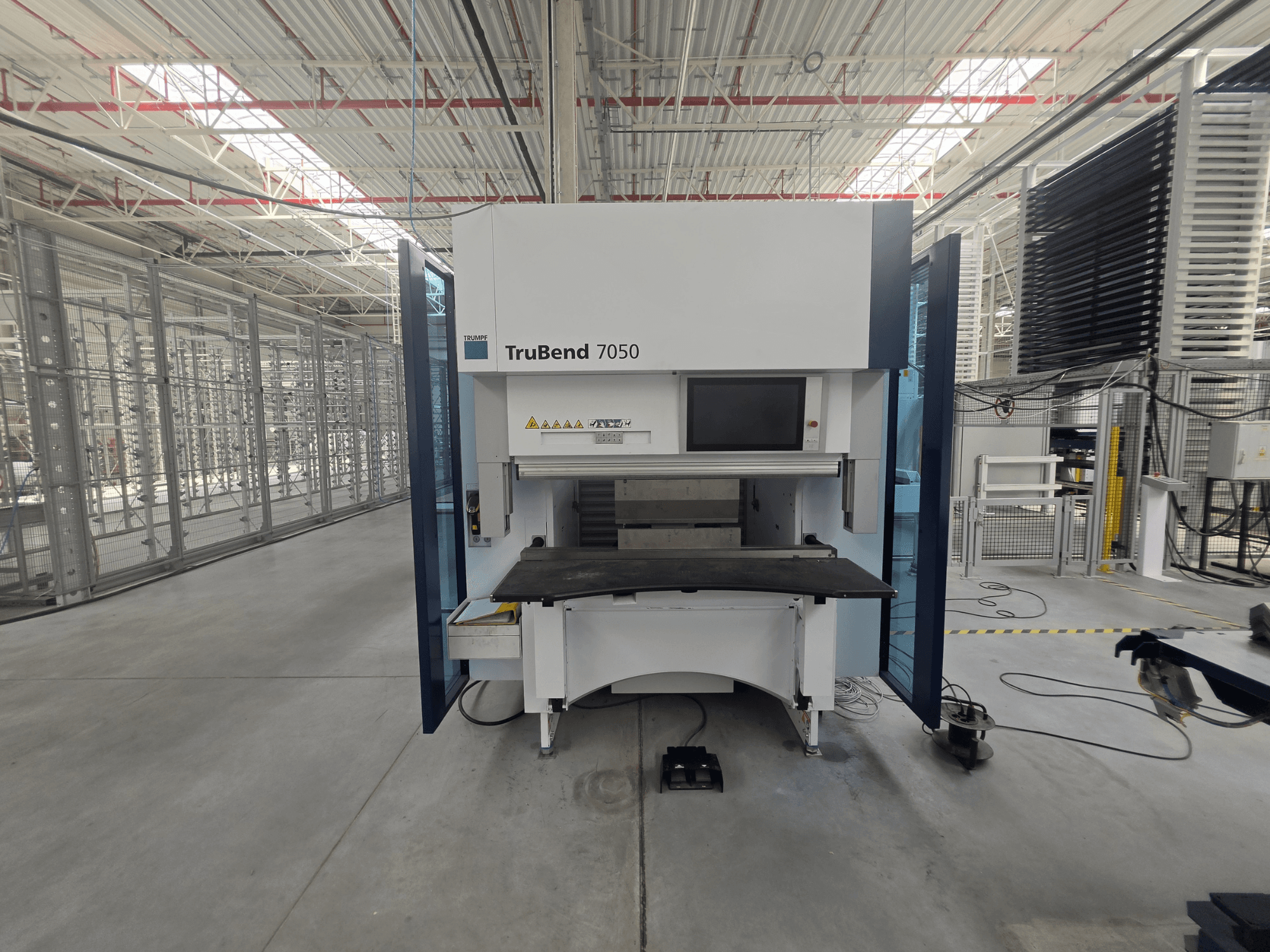 Front view of TRUMPF TruBend 7050 press brake, showcasing control panel and work table in a well-lit industrial setting.