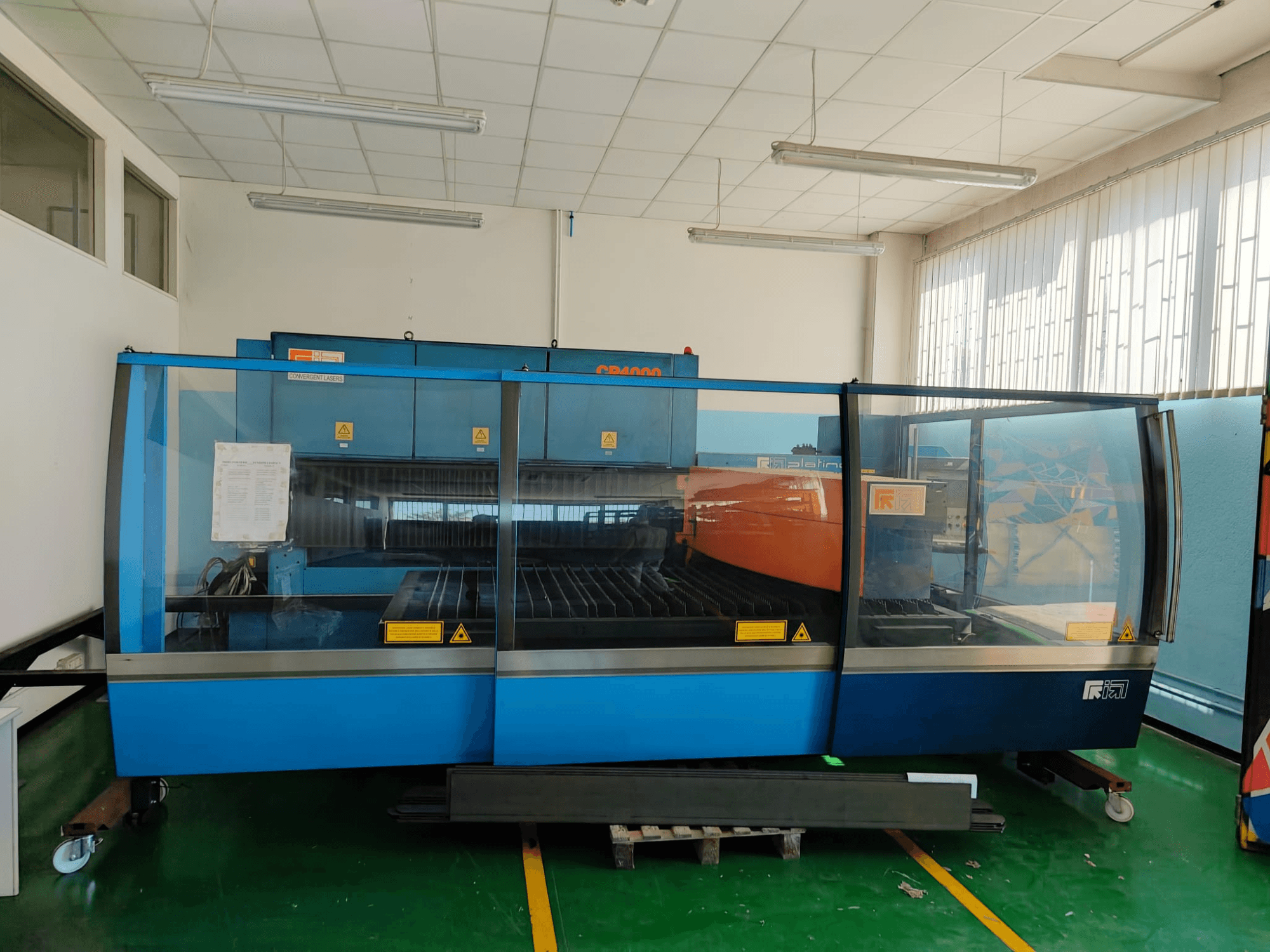 Front view of a CONVERGENT LASERS CP4000 CO2 laser cutting machine with a blue and orange design, in a well-lit workshop setting.