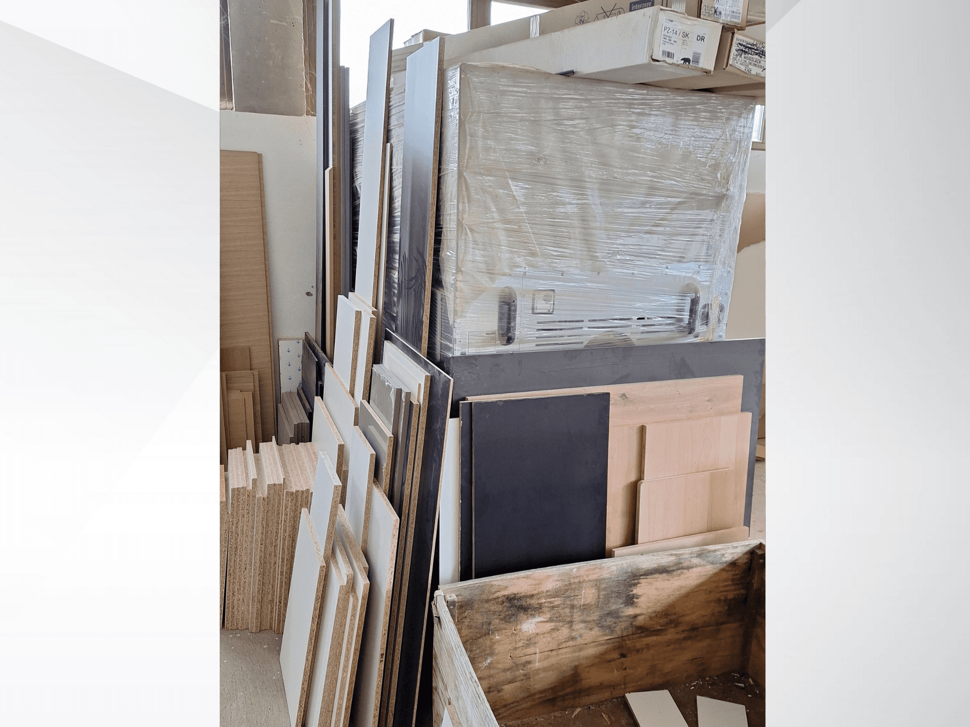 Assorted plywood panels and boards stacked, showcasing various finishes; front view of materials in a workshop setting.