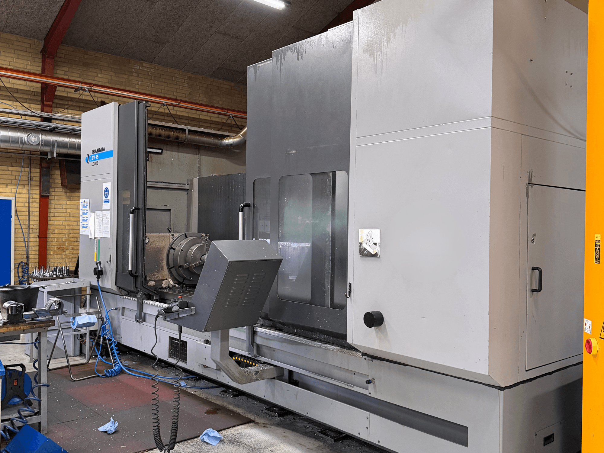 IBARMIA ZV45 L3000 vertical machining center, front view; large metal enclosure, control panel, visible tooling setup.