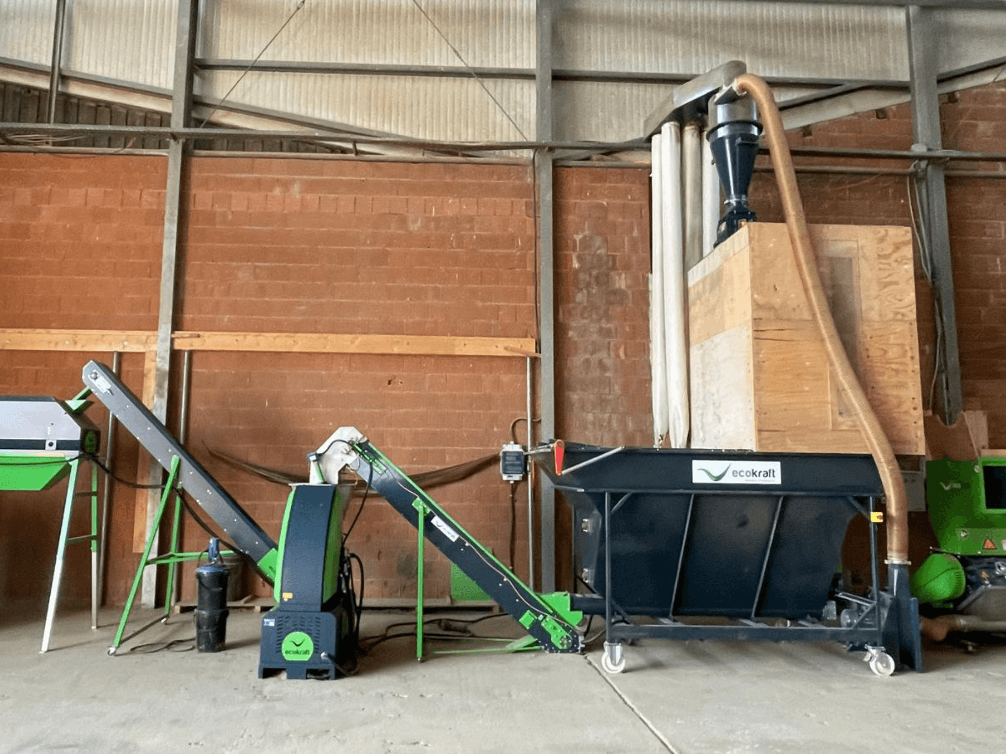 ECOKRAFT LP 22 machine tool in a warehouse, featuring a conveyor and dust collection system. Side view, highlighting functional components.