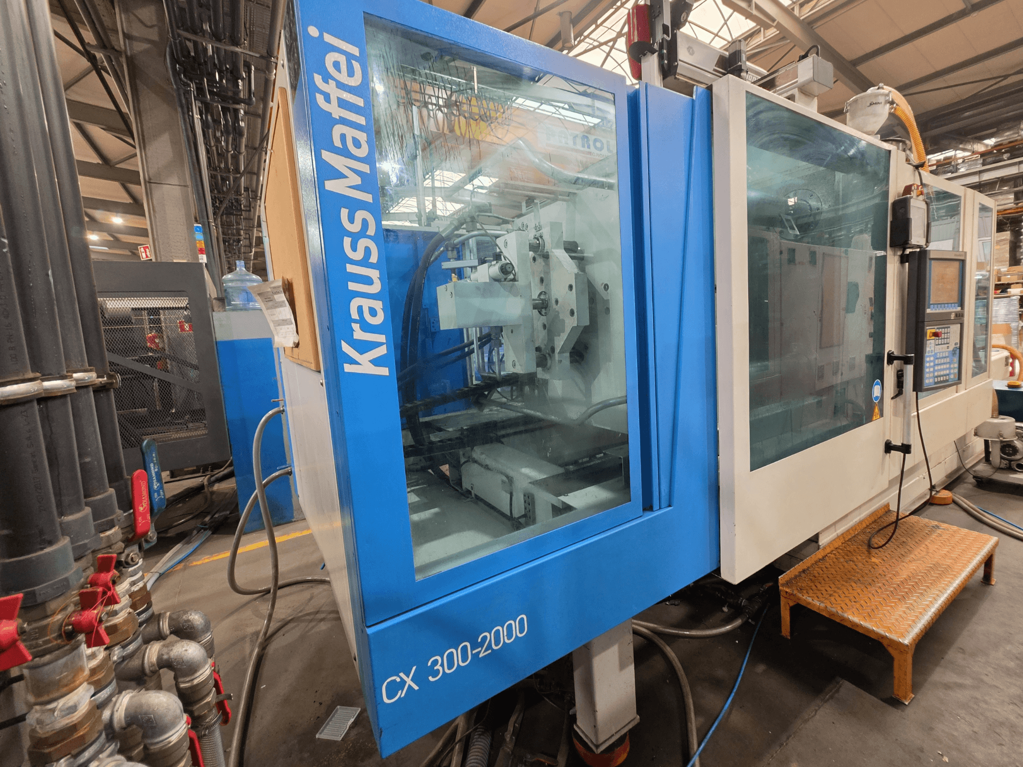 Krauss Maffei CX 300-2000 hydraulic injection moulding machine, front view, showing control panel and hydraulic lines.