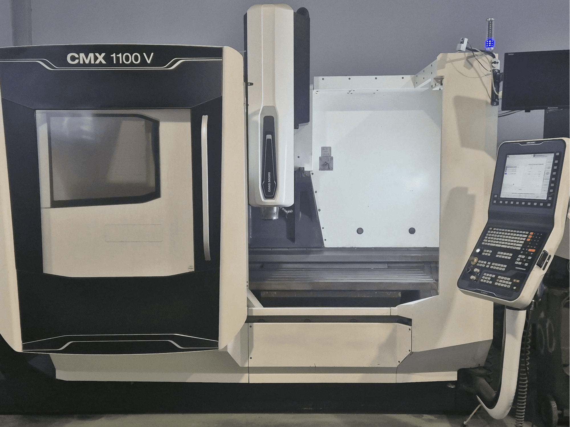 DMG MORI CMX 1100 V vertical machining centre, front view showcasing control panel and machine bed.