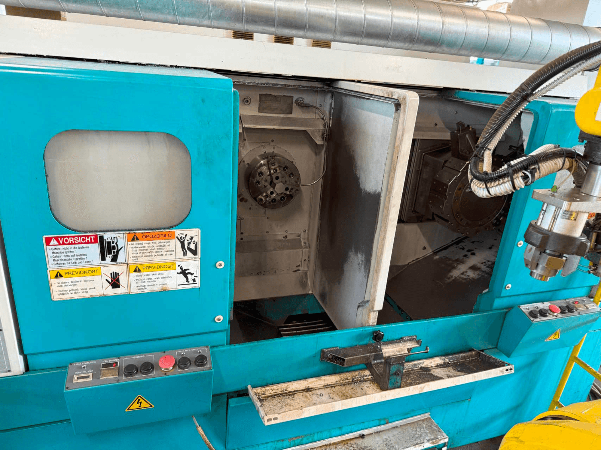 DOOSAN H310T horizontal turning machine, front view showing control panel and spindle area with safety warnings.