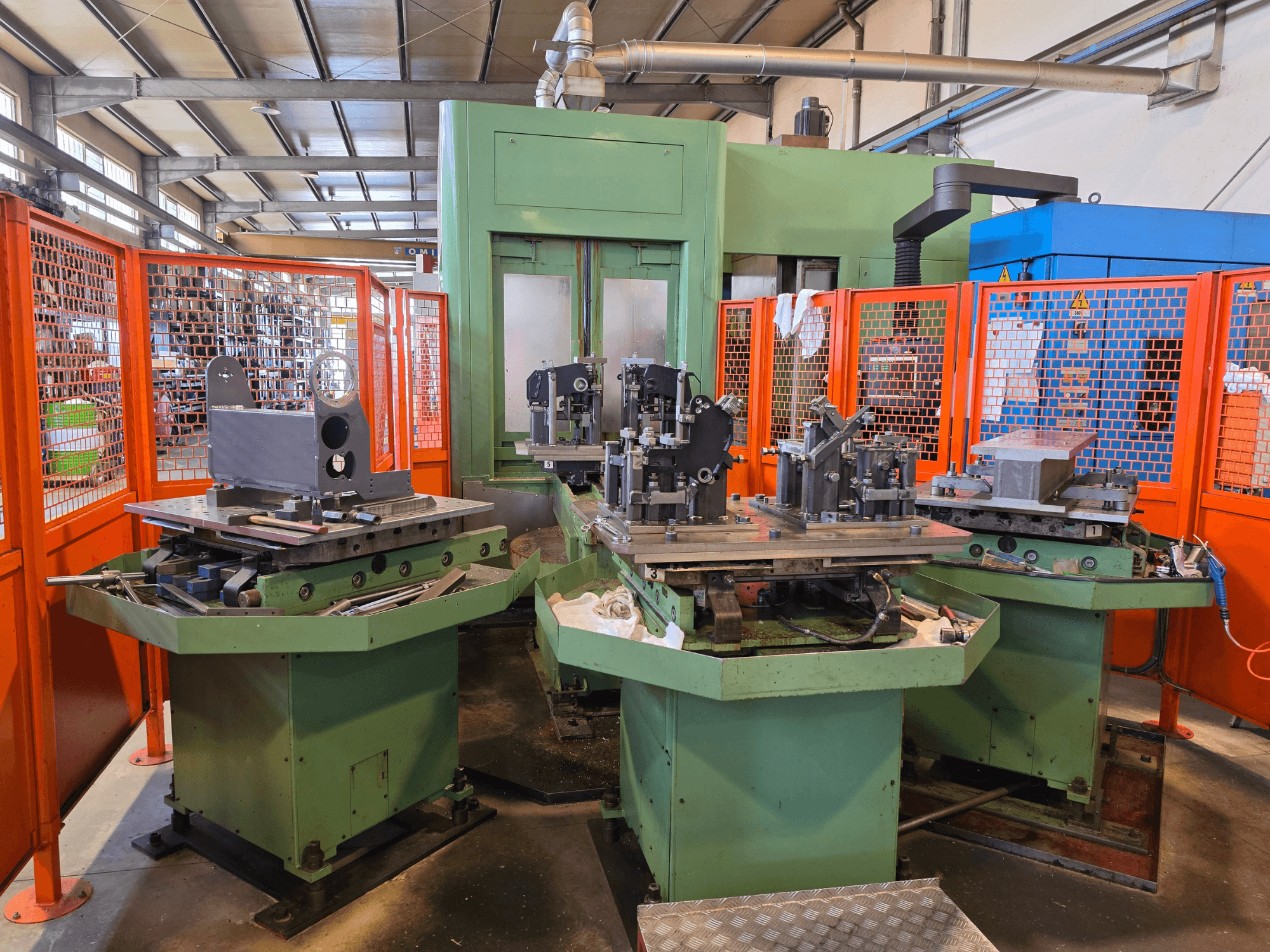 Front view of Mandelli R.S. M7U Horizontal Machining Centre with three workstations, metal components, and safety enclosures.