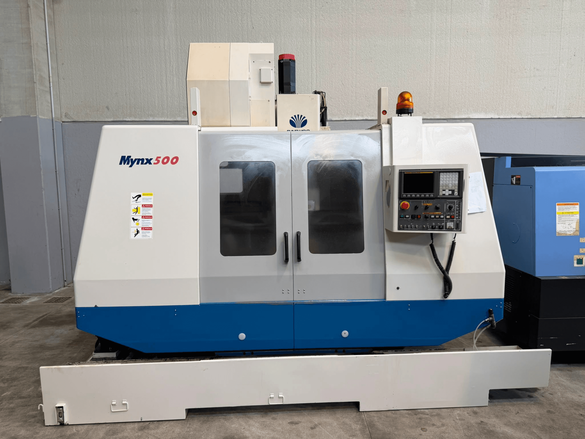 DAEWOO MYNX 500 vertical machining center in front view with a control panel, safety lights, and clear access doors.