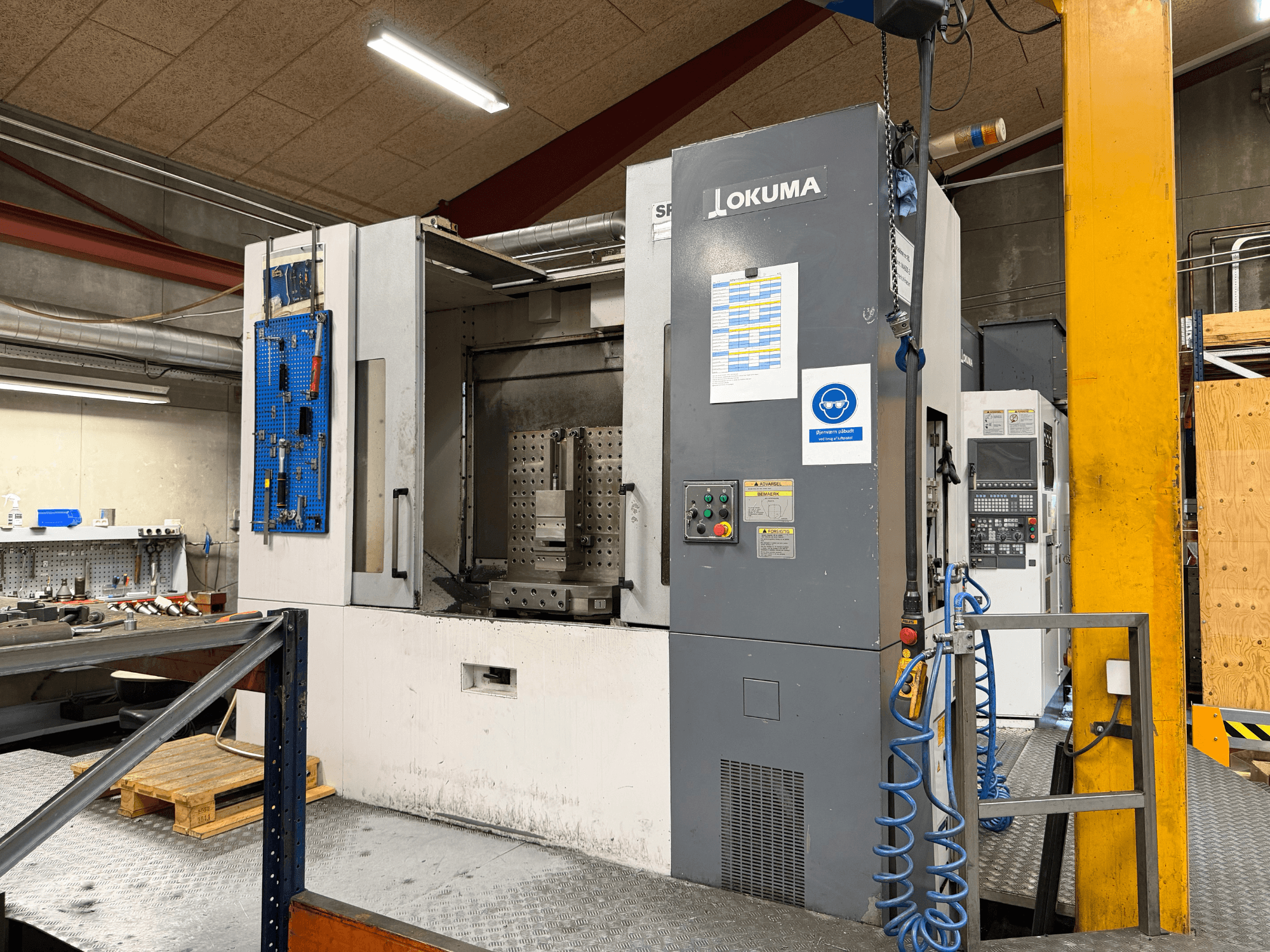 Okuma MA-600HB horizontal machining centre in a workshop, front view showing control panel and work area.