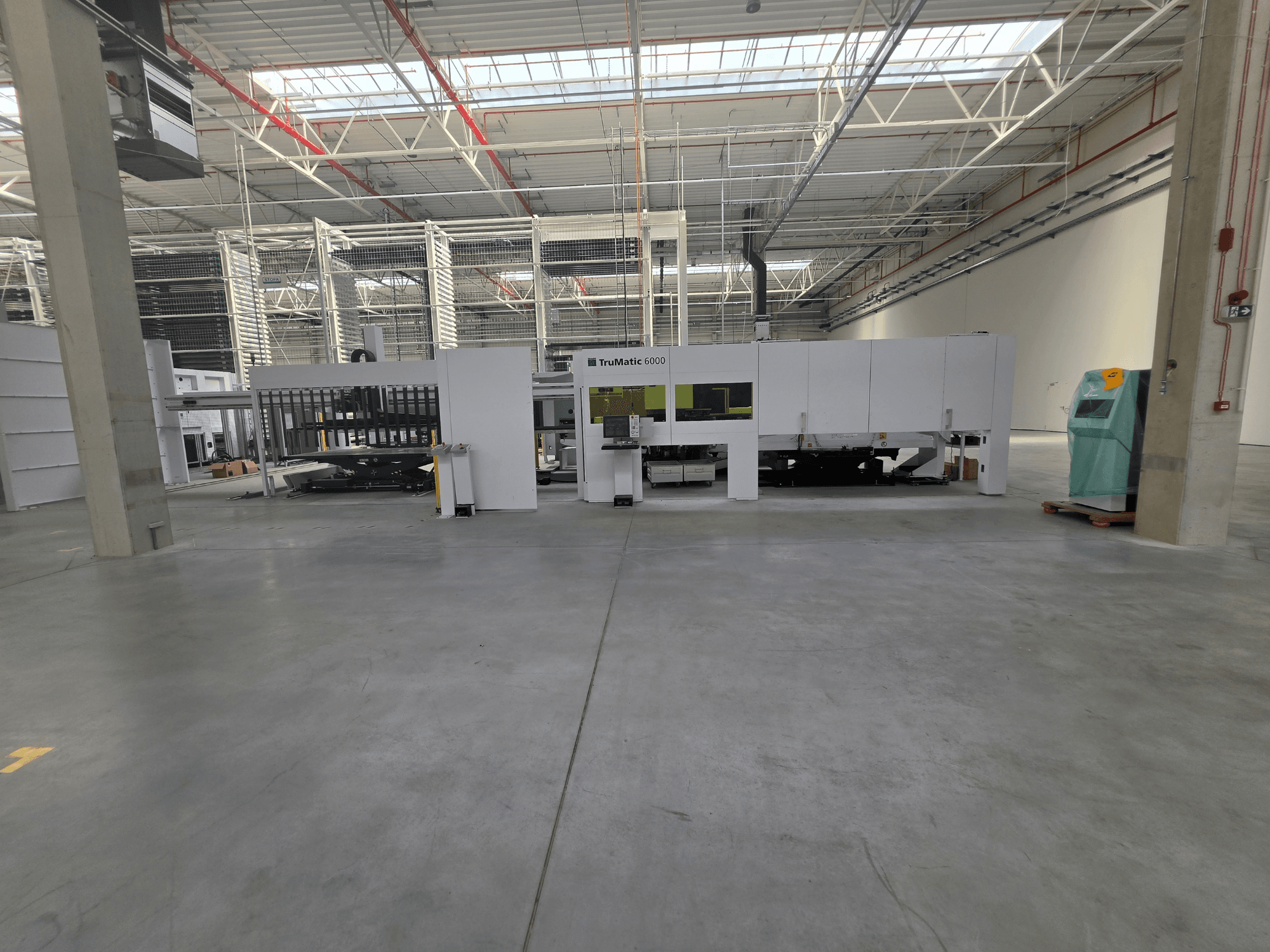 TRUMPF TruMatic 6000-1600 fiber punch-laser combo machine in a spacious warehouse, viewed from the front.