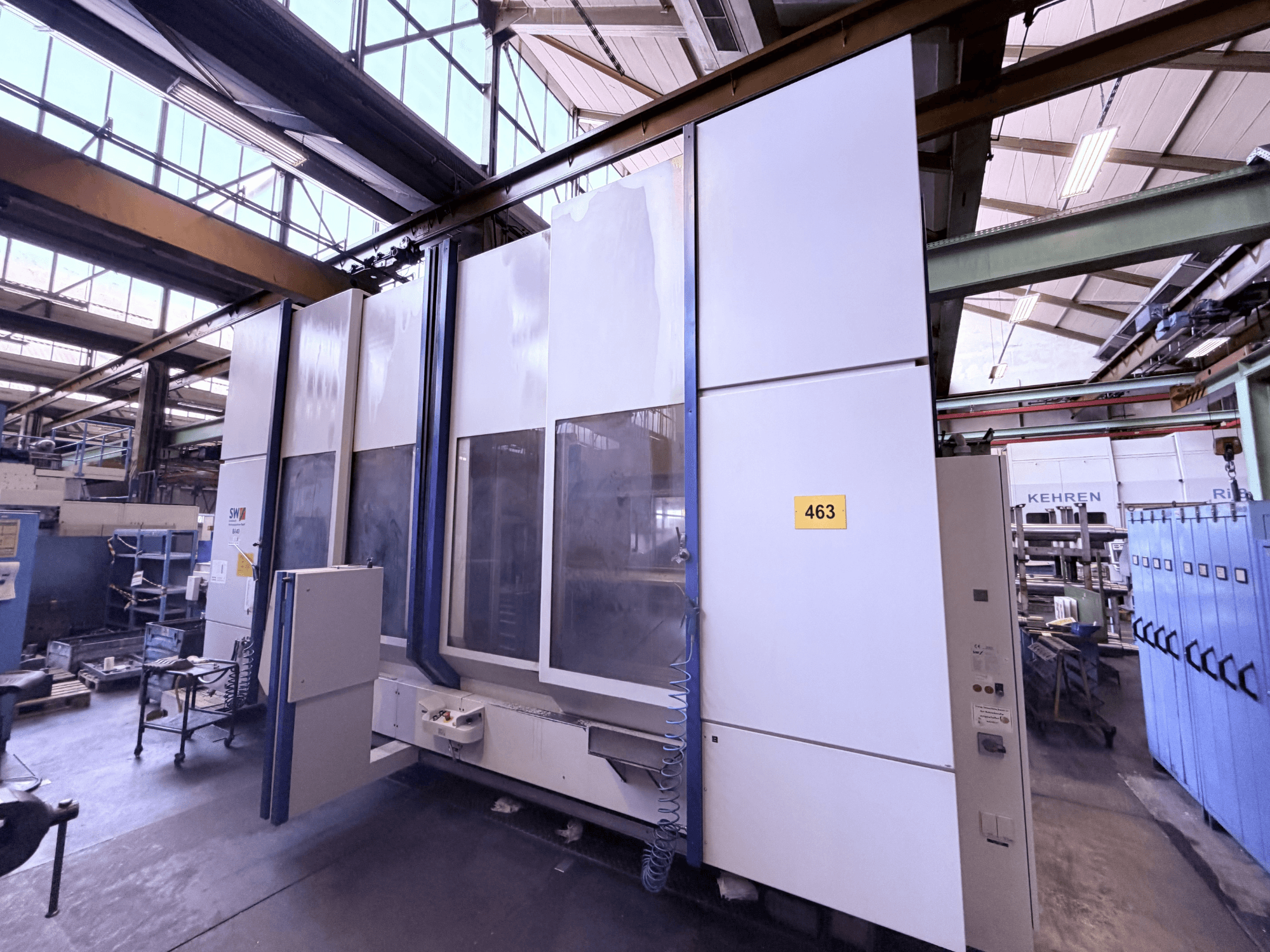 Vertical machining center SW BA 40, side view, showing control panel, large work area, and surrounding industrial environment.