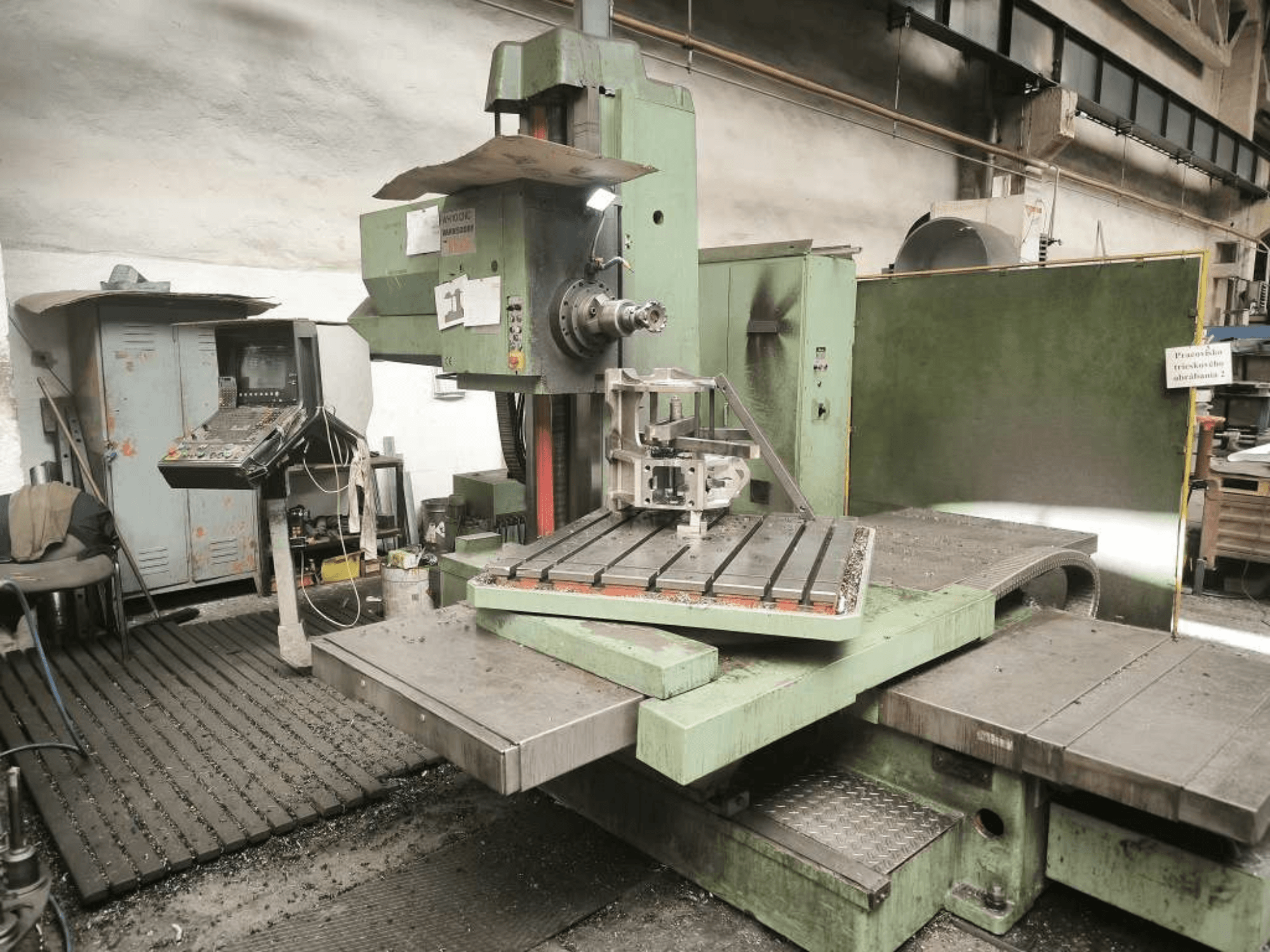 TOS WH 10 CNC boring machine viewed from the front, showcasing a machined workpiece on the table and control panel.
