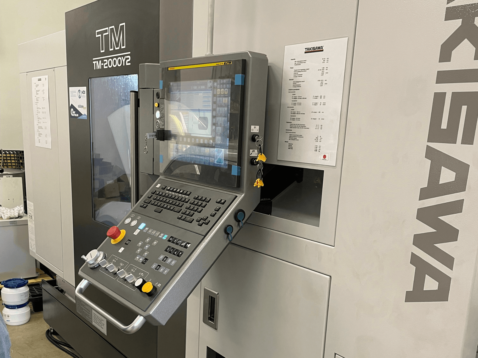 Takisawa TM-2000Y2 horizontal turning machine control panel in front view, featuring a digital display and operational buttons.