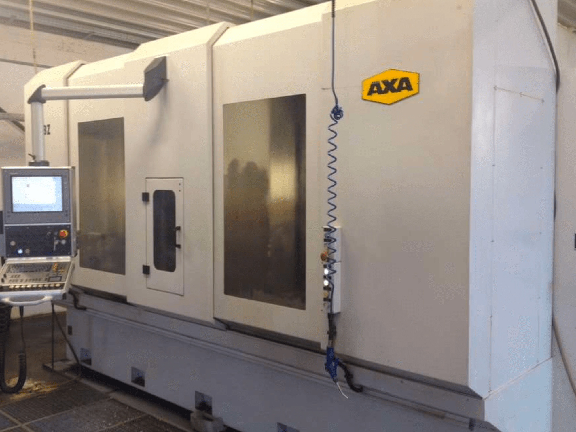 AXA DBZ vertical machining centre viewed from the front, featuring a control panel and large transparent safety windows.