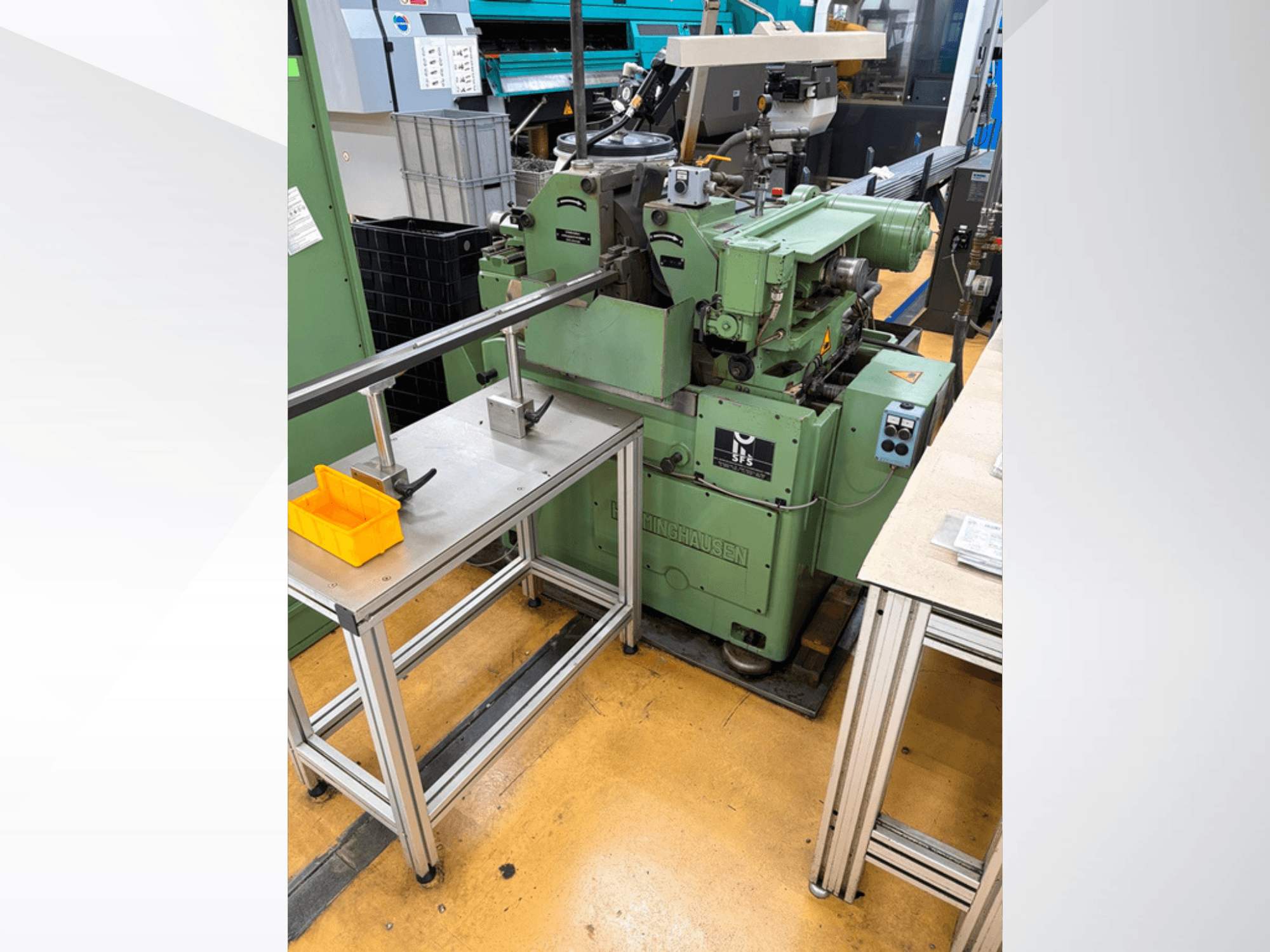 HERMINGHAUSEN SR 2 W centerless grinding machine in green, front view, positioned beside a metal work table with tools.